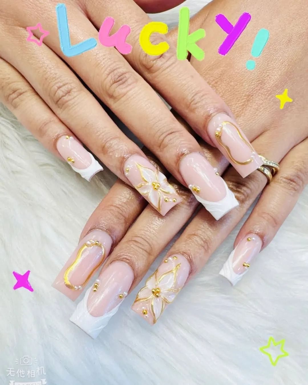 Long square pink-and-white French with raised gold outlines (Lucky text overlay)