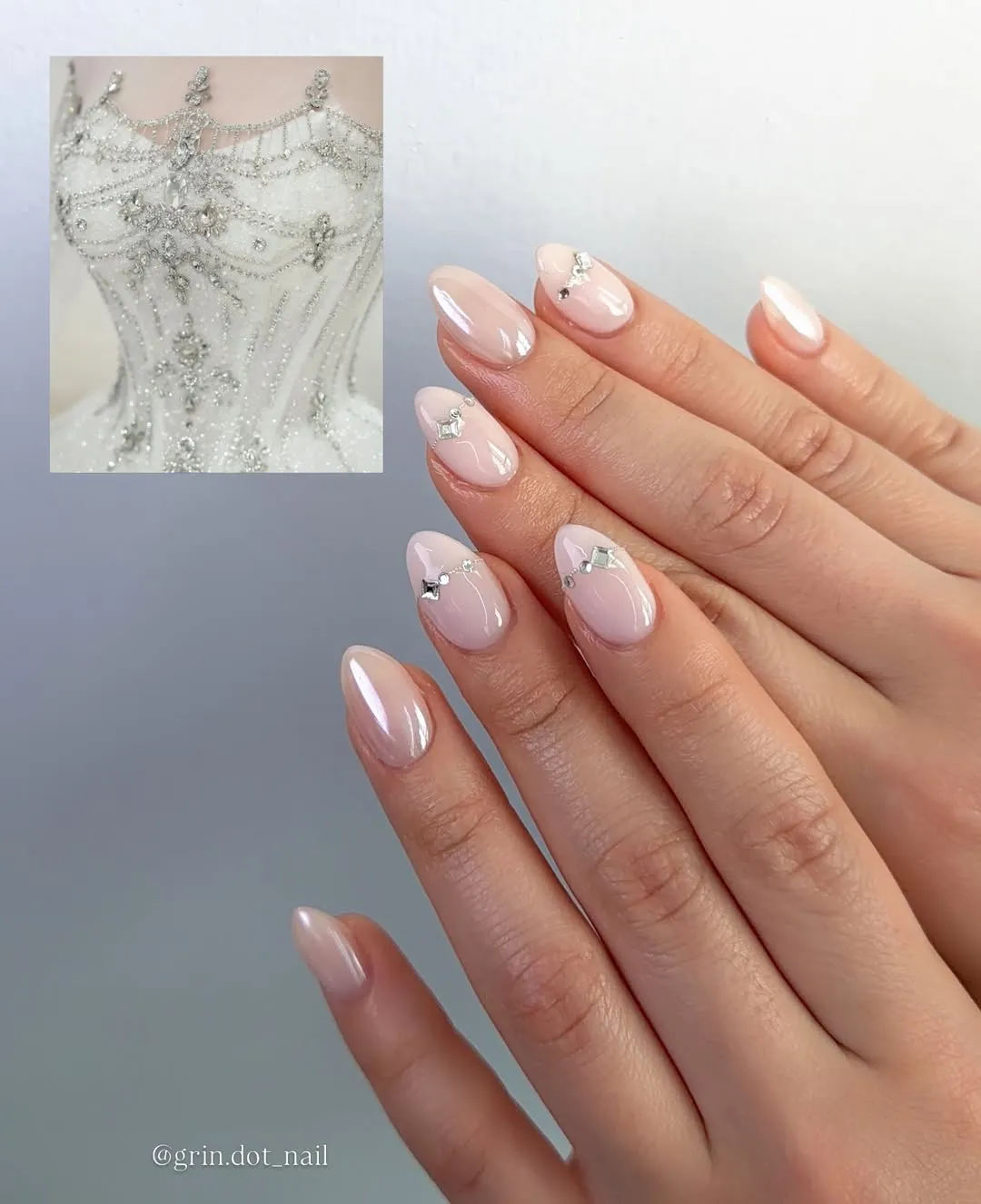 Glossy pearly nude nails with minimal rhinestone accents
