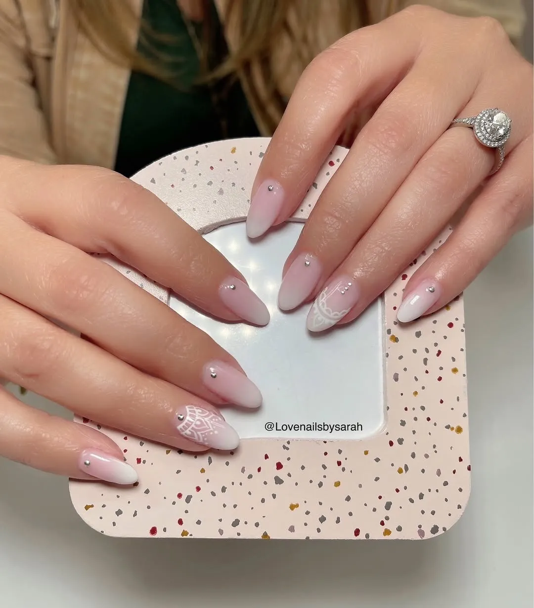 Soft ombré white tips with lace-like detail and single studs