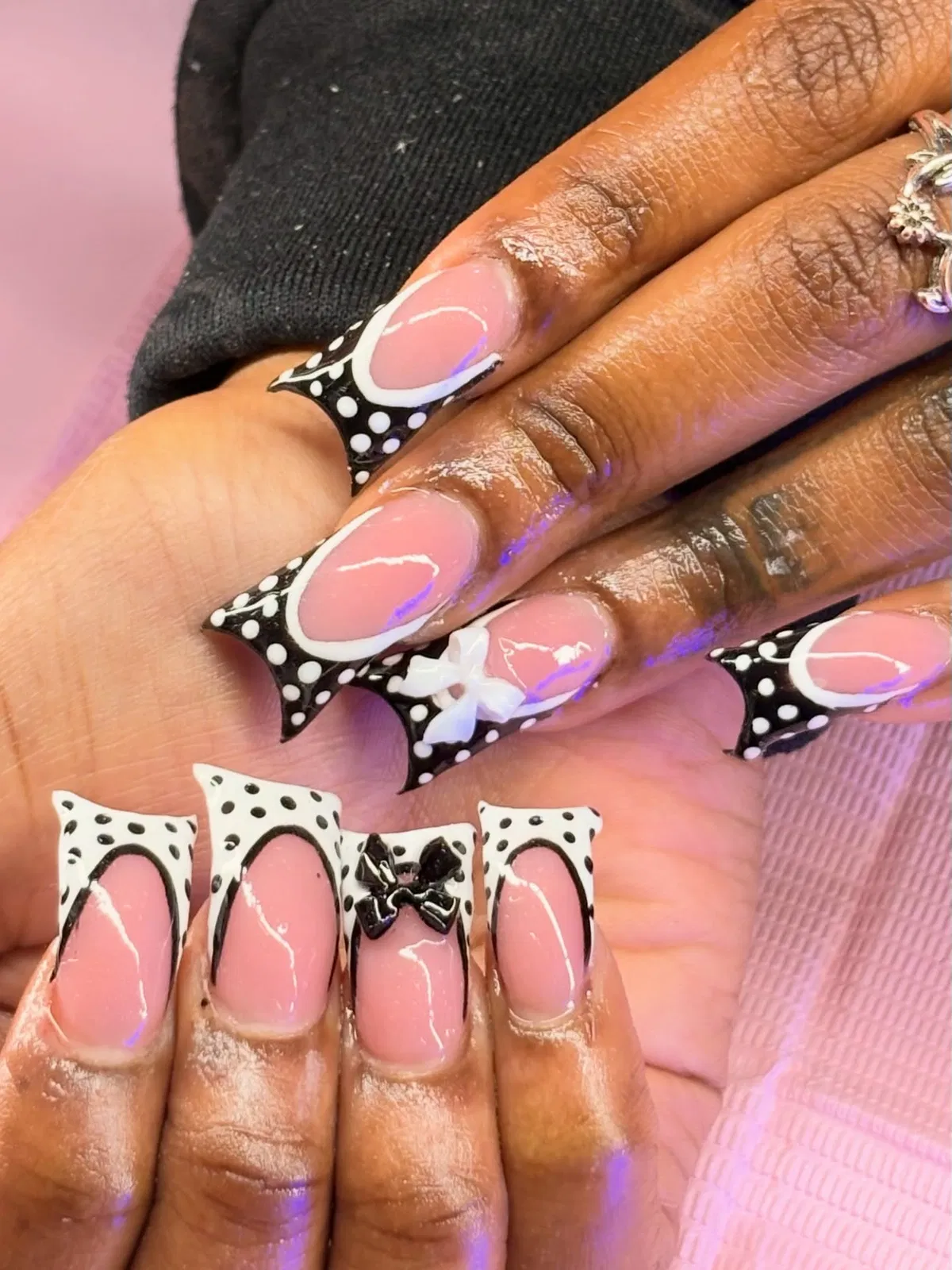 Pink base with dramatic polka dot French tips and 3D bows