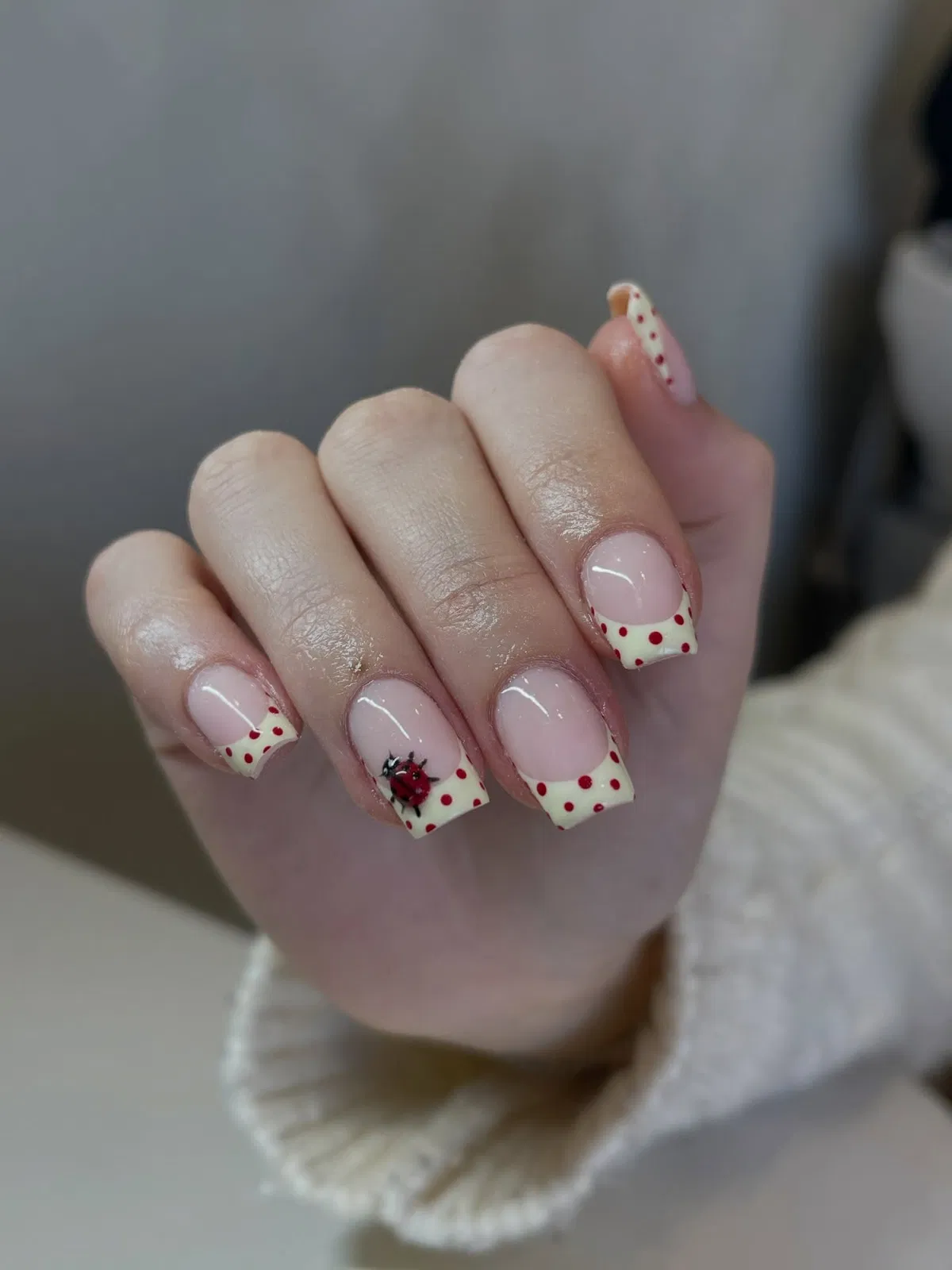 Red polka-dot yellow French tips with ladybug detail