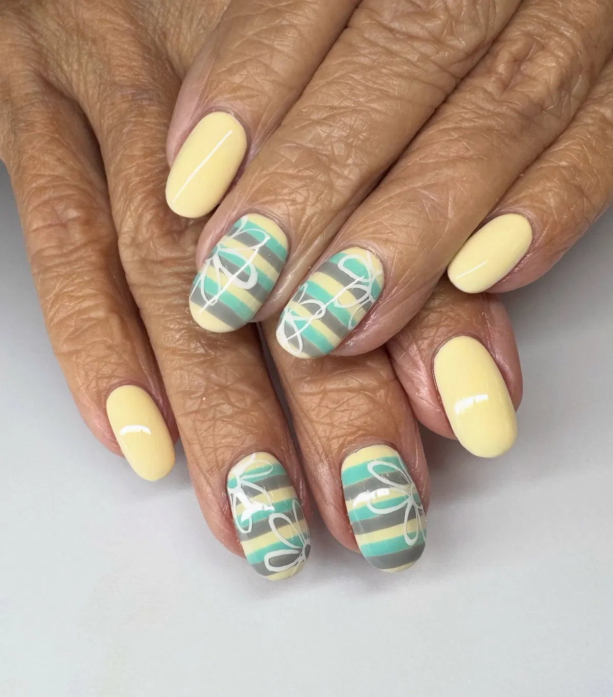 Pale Yellow Nails with Striped Accents and White Line Art