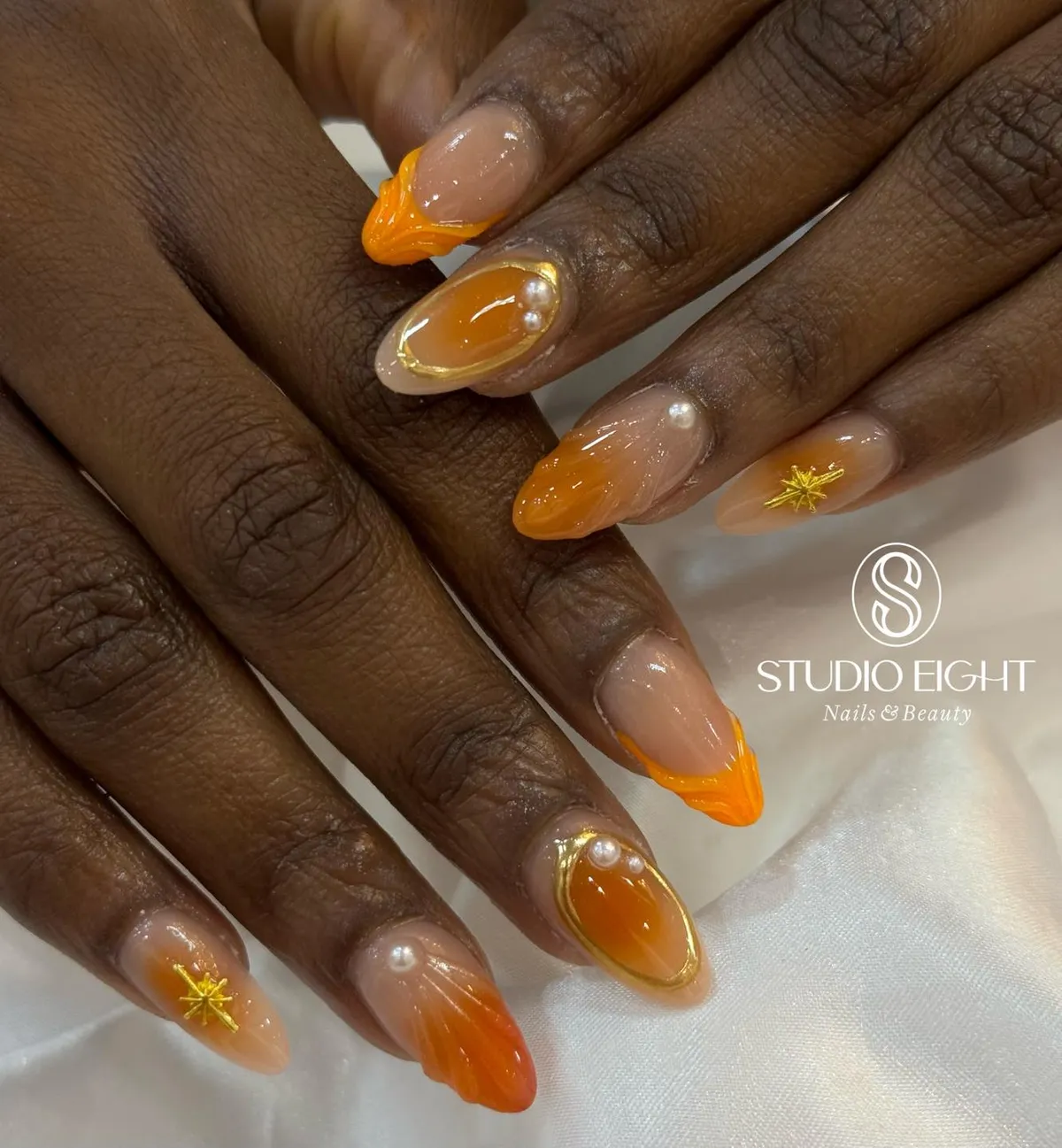 Orange aura fades with gold ovals and pearls