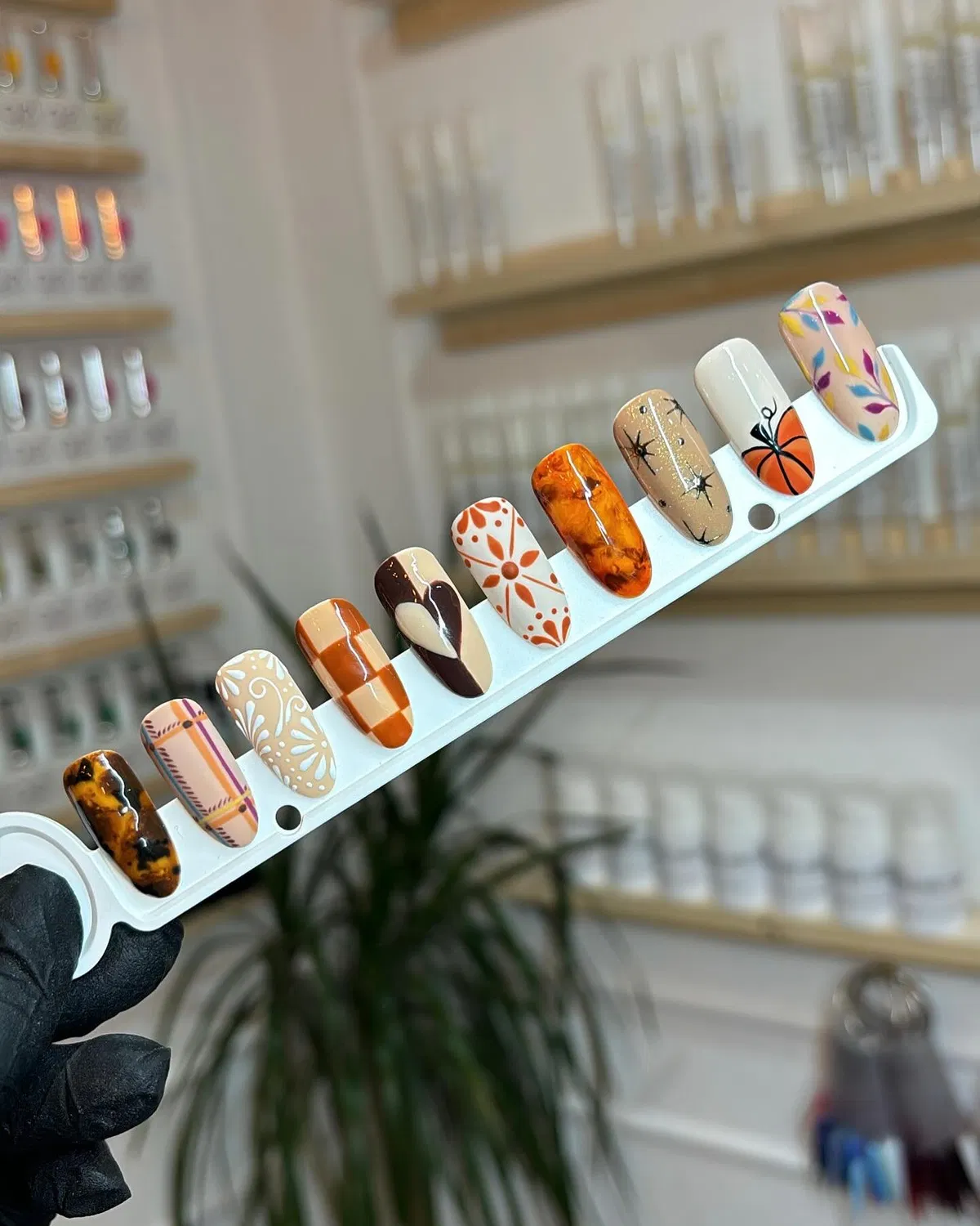 Autumn-toned nail tip sampler with plaid, florals, and tortoiseshell