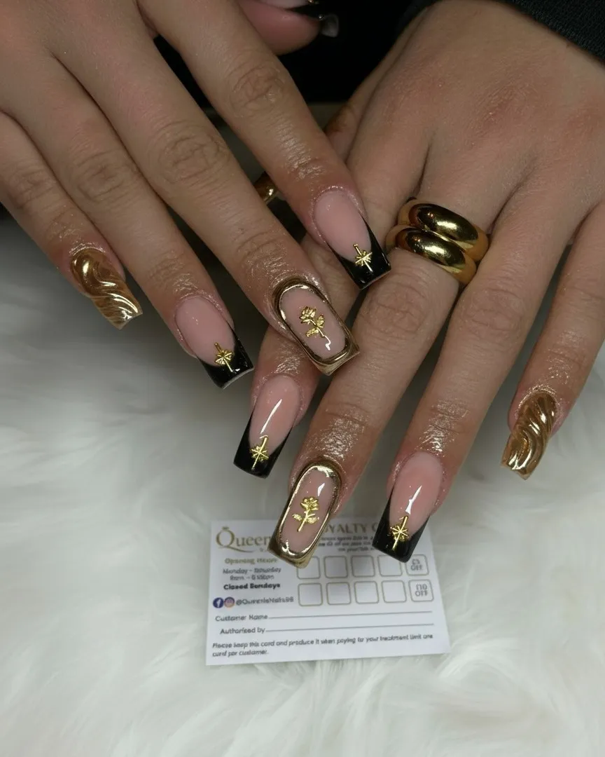 Nude-and-black French tips with gold starburst accents