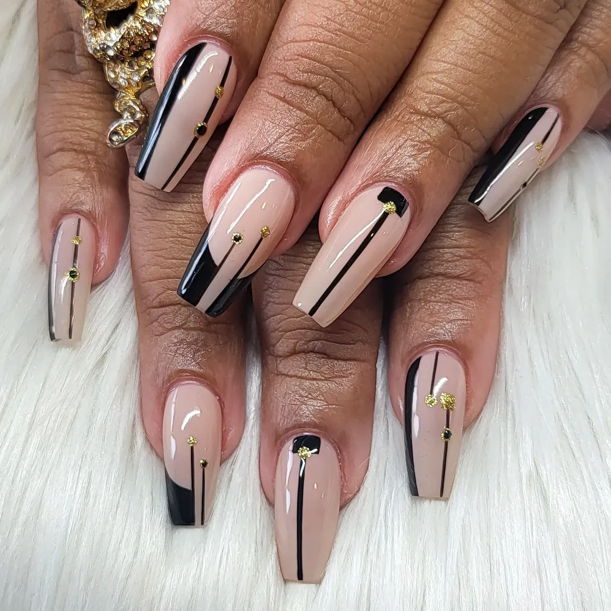 Minimal nude-and-black lines with gold dot accents