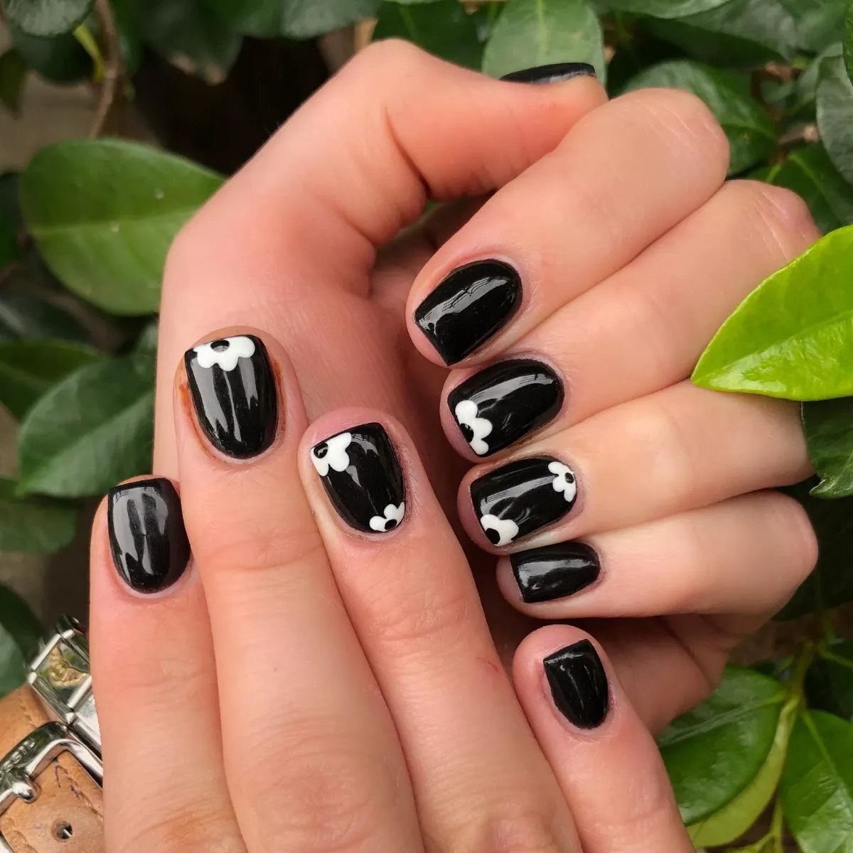 Nude almond nails with black tips and repeated yin-yang accents