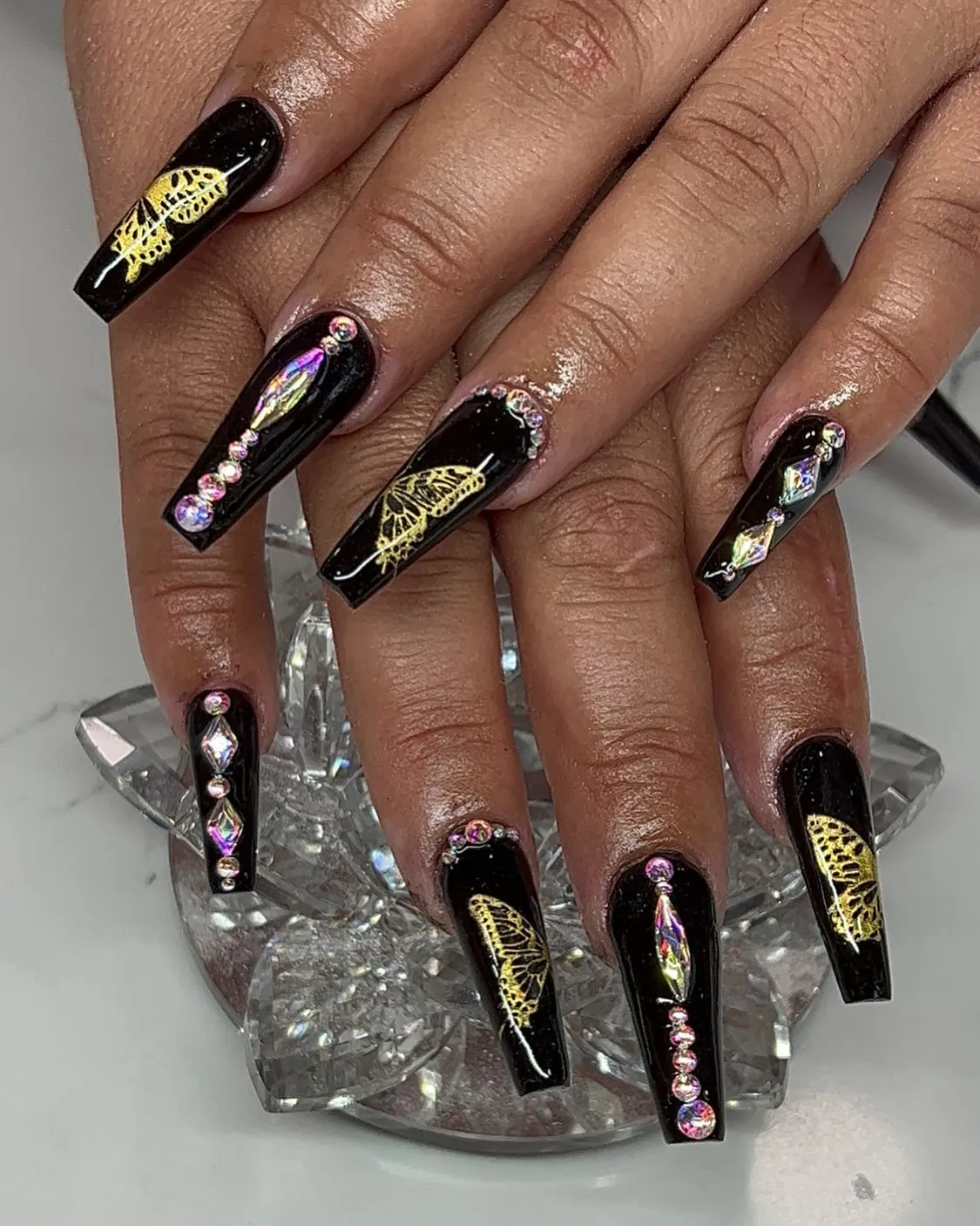 Nude base with black French tips and rhinestone clusters (including a heart-shaped gem)