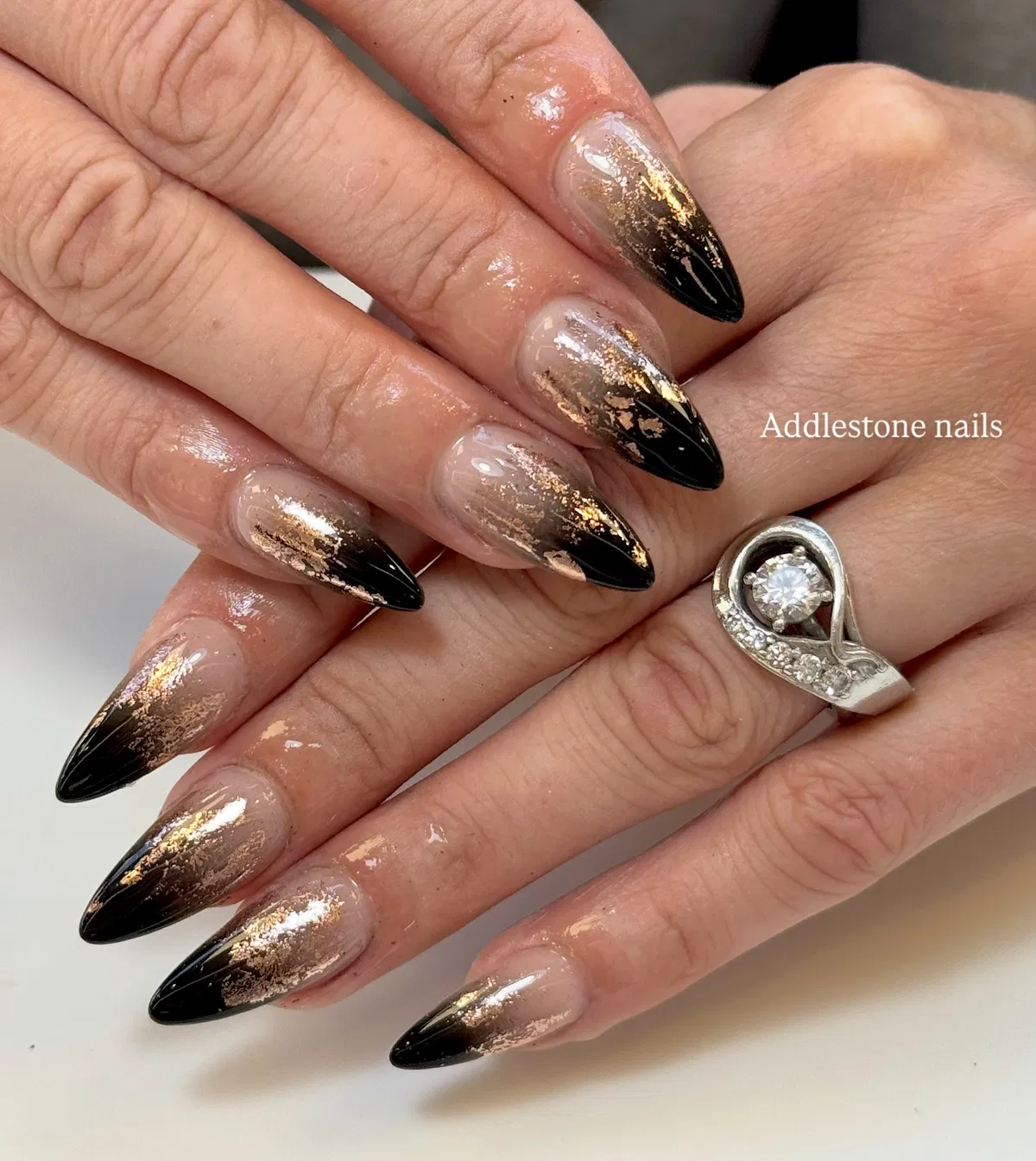 Black pointed tips with gold fleck accents on nude base