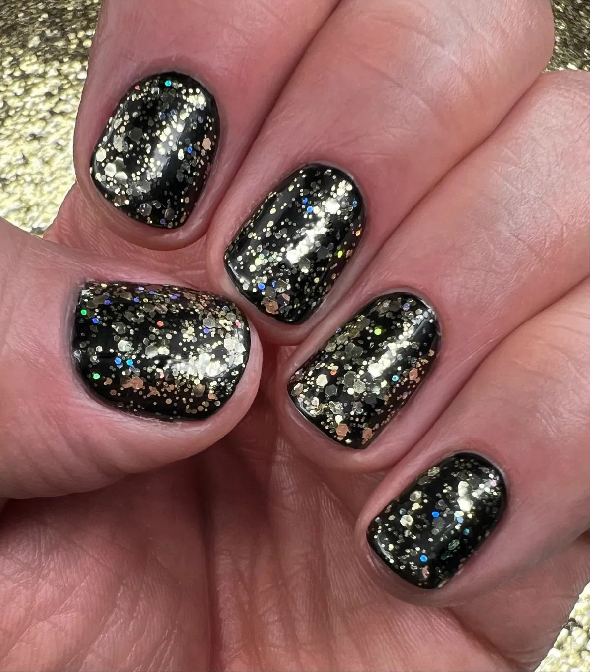 Black nails with dense gold and holographic glitter mix