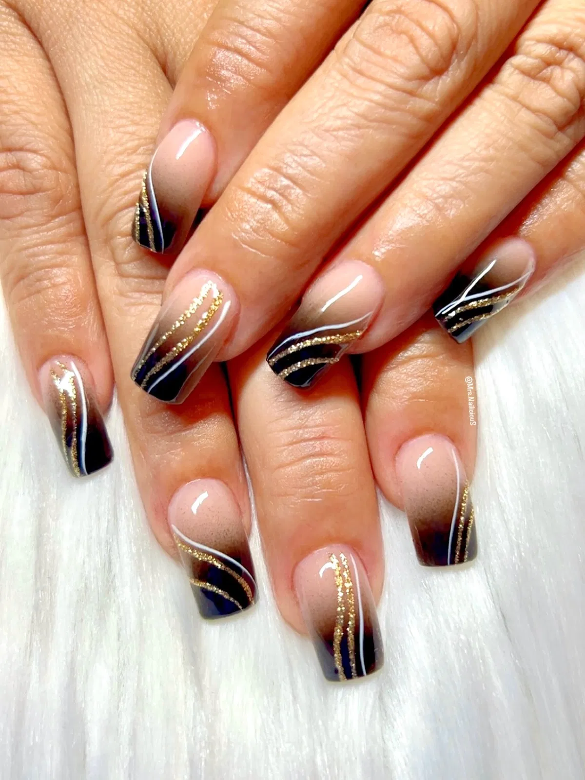 Glossy nude-to-black ombre with gold-lined accents