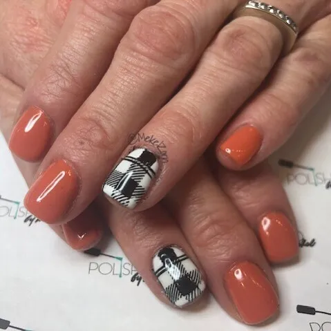 Orange manicure with black-and-white plaid accent nails