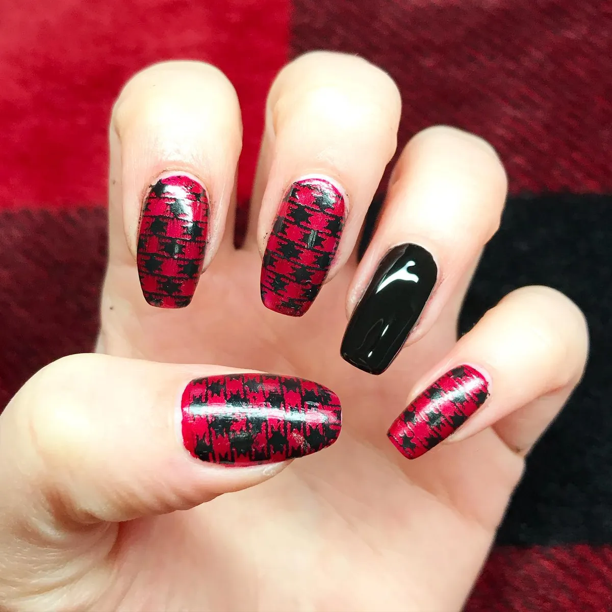 Red-and-black distressed plaid look with one solid black nail