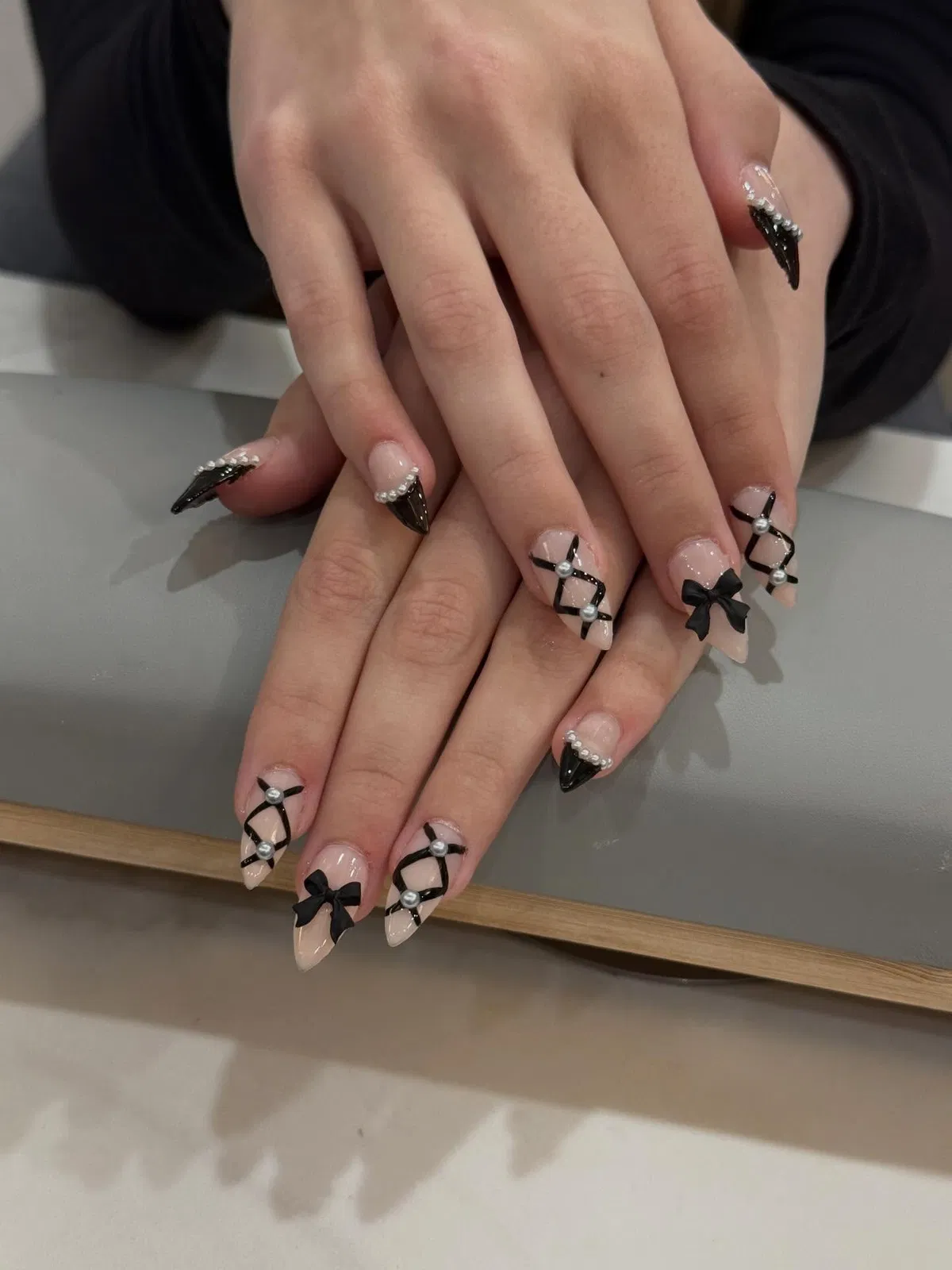 Crisscross black lines with pearl-like beads and black bow accents