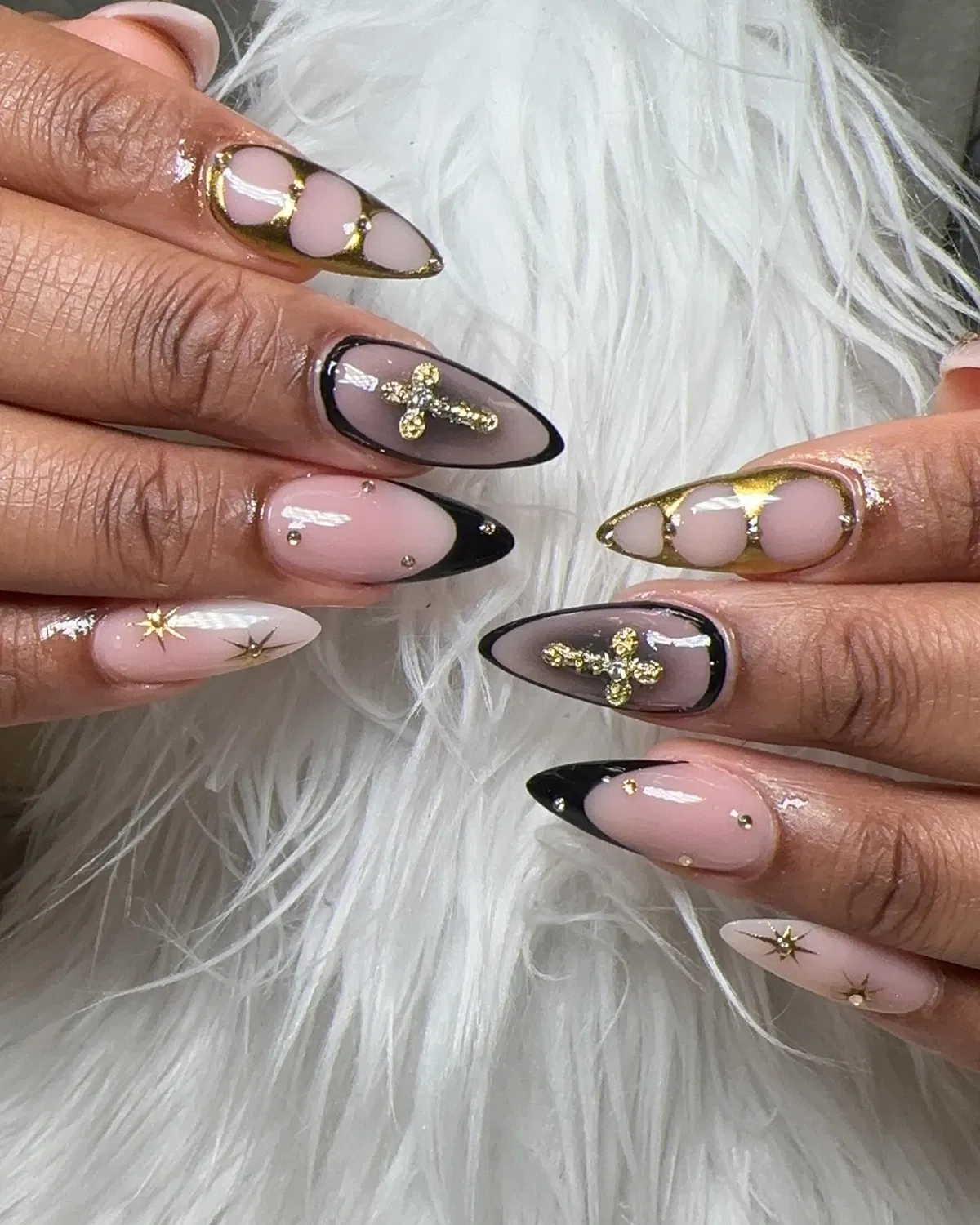 Black French tips with gold cross charms and starburst accents