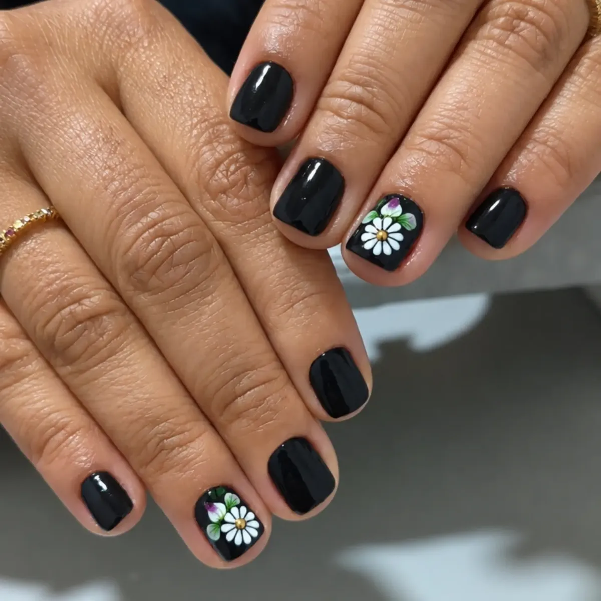 Short glossy black square nails with daisy accent nails