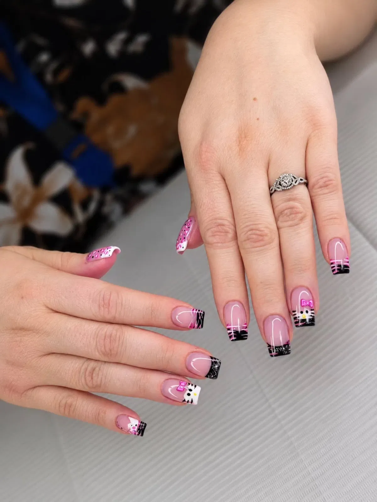 Pink and black French tips with hot-pink accents and a face graphic detail