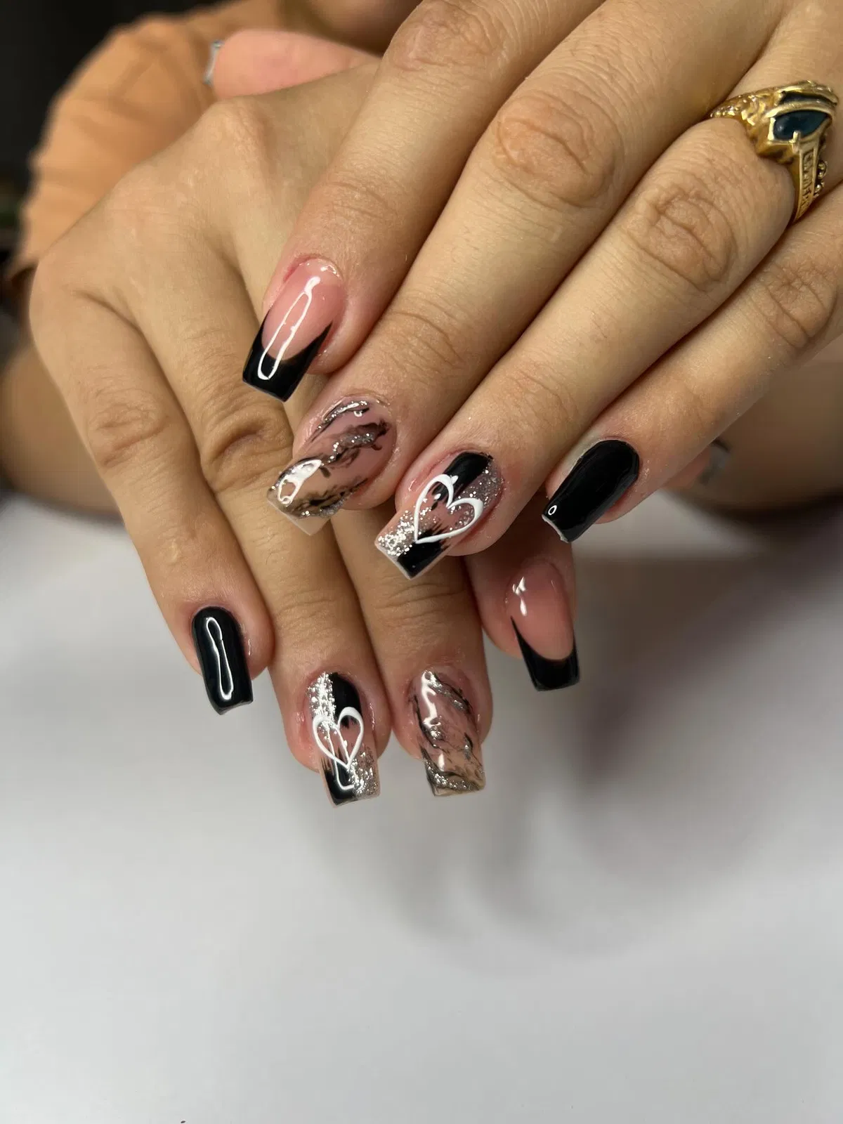Black and nude square nails with glitter and white heart outlines