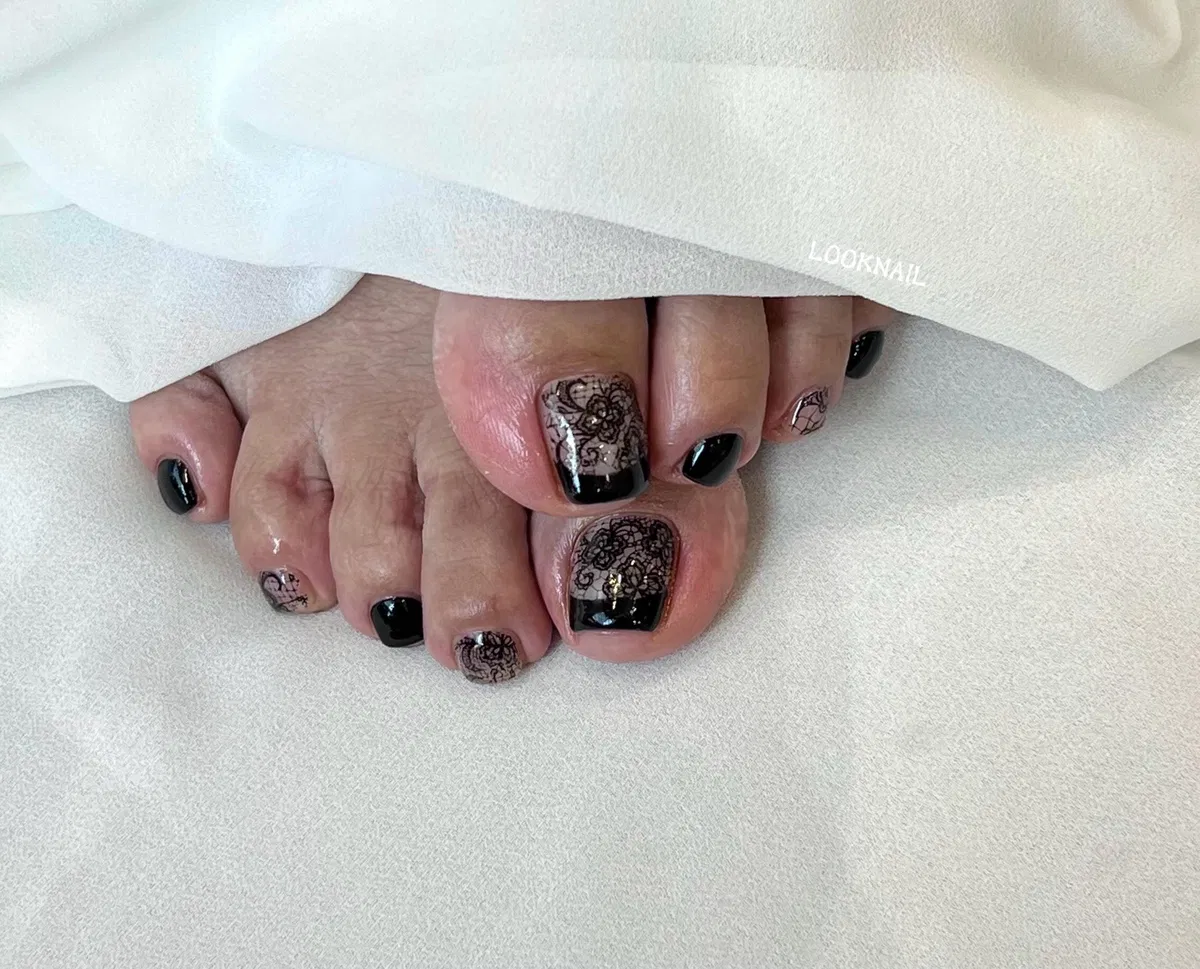 Black-tipped nude big toes with lace-like floral linework