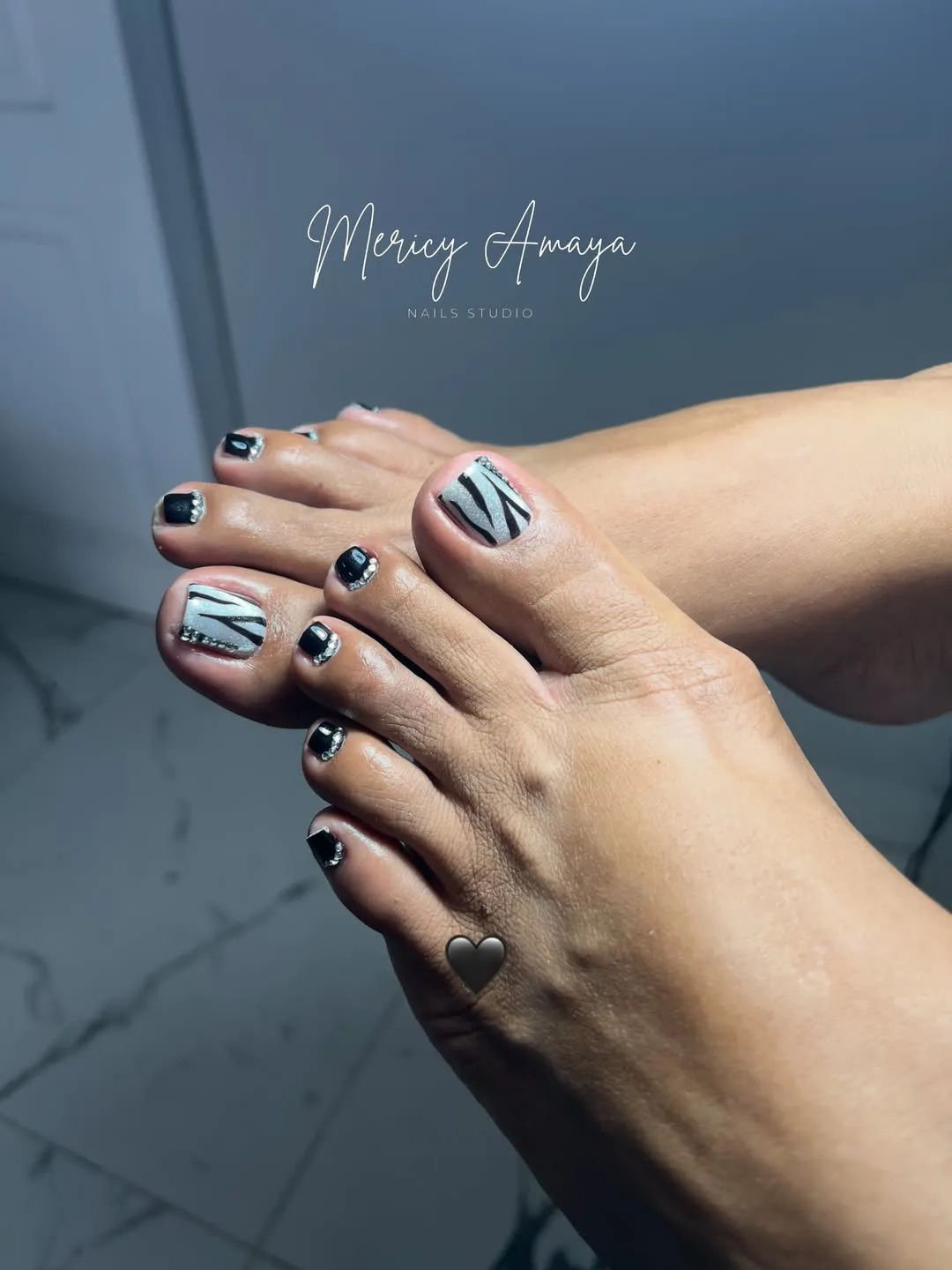 Zebra-striped silver big toes with black glitter-accent nails