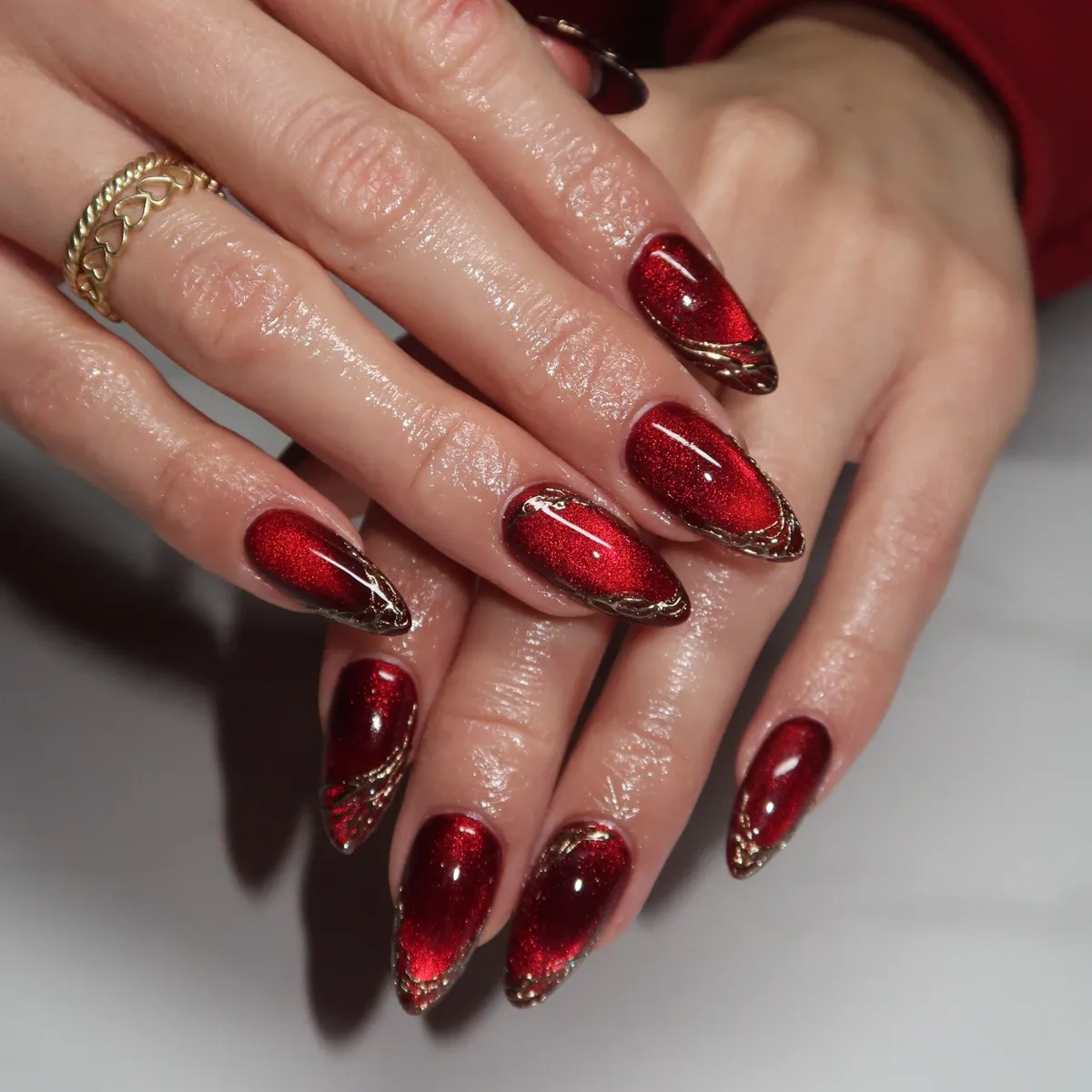 Red glitter almond nails with gold swirls