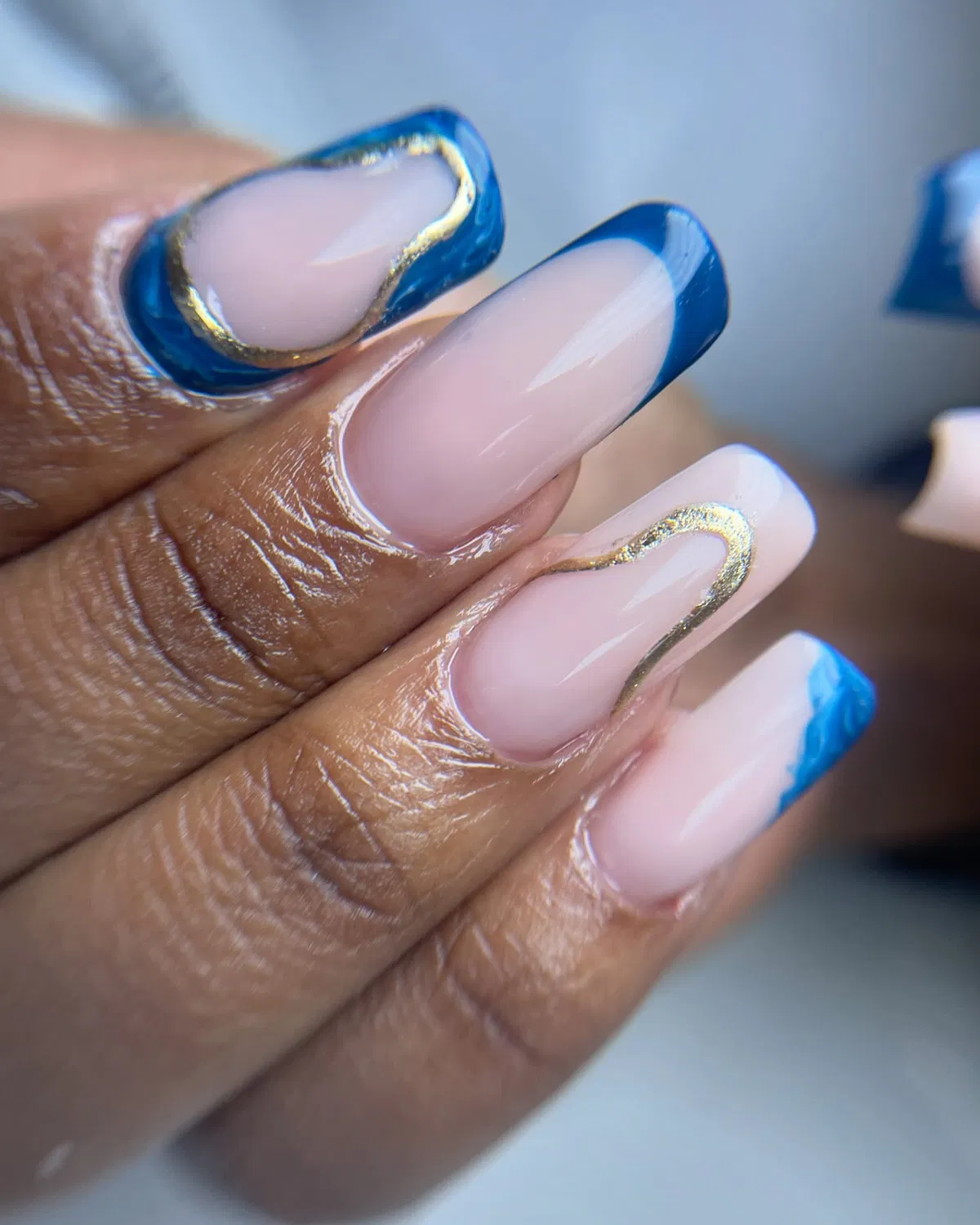 Nude Base with Blue French Tips and Gold Curves