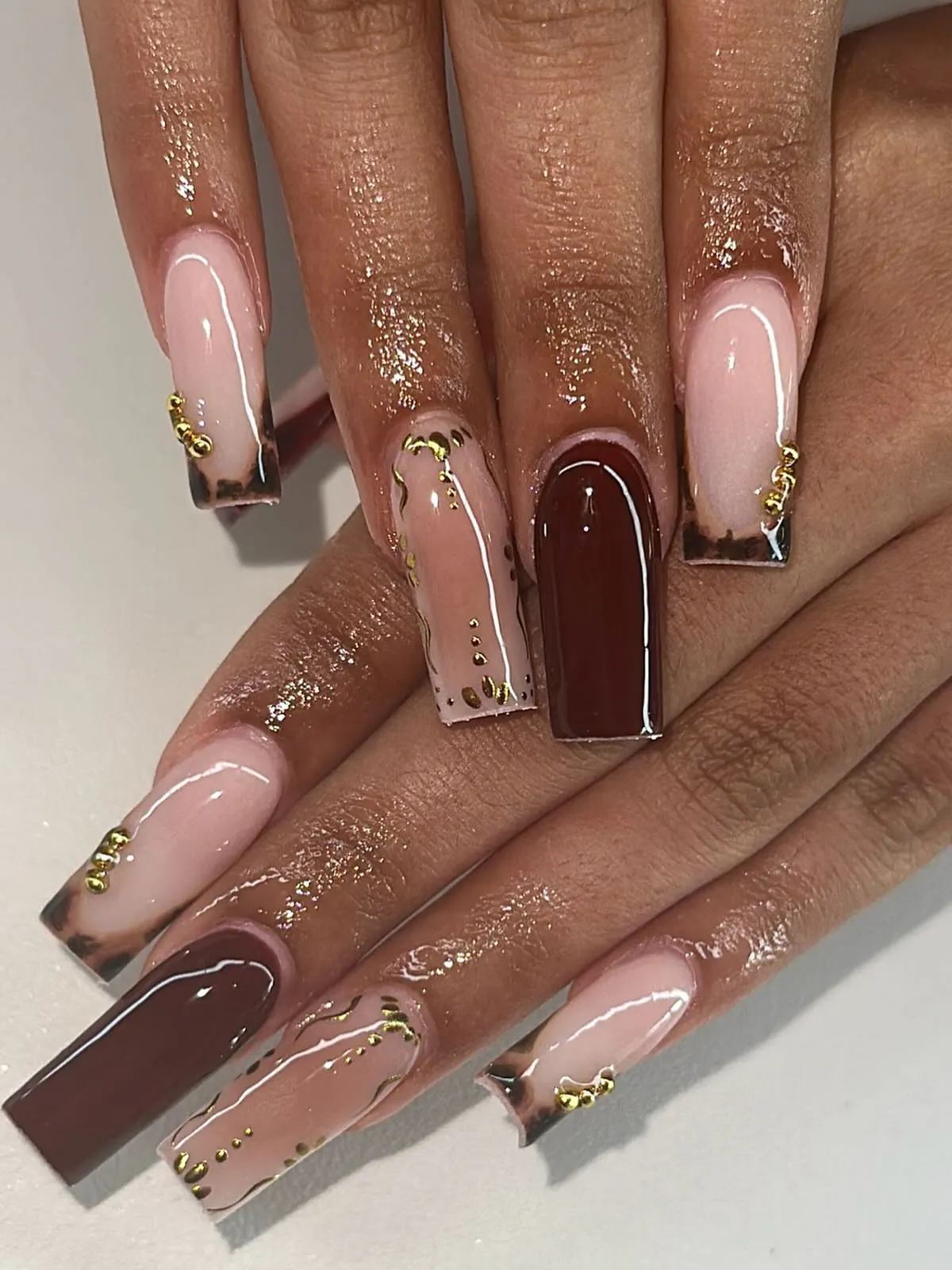 Glossy nude-and-brown coffin set with gold stud accents