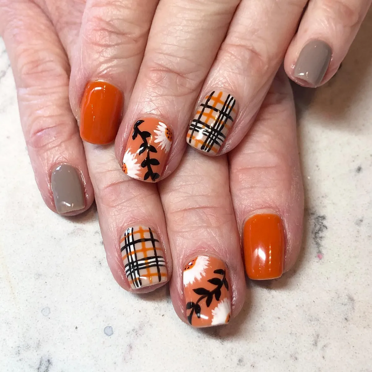 Cream plaid accents with orange solids and floral nail art