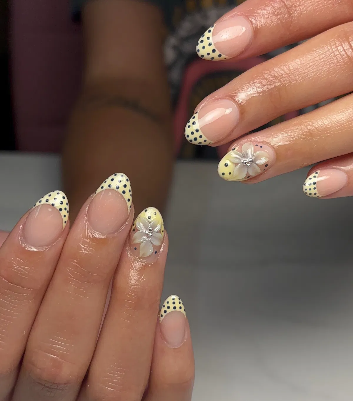 Polka-dot yellow French tips with 3D floral accents