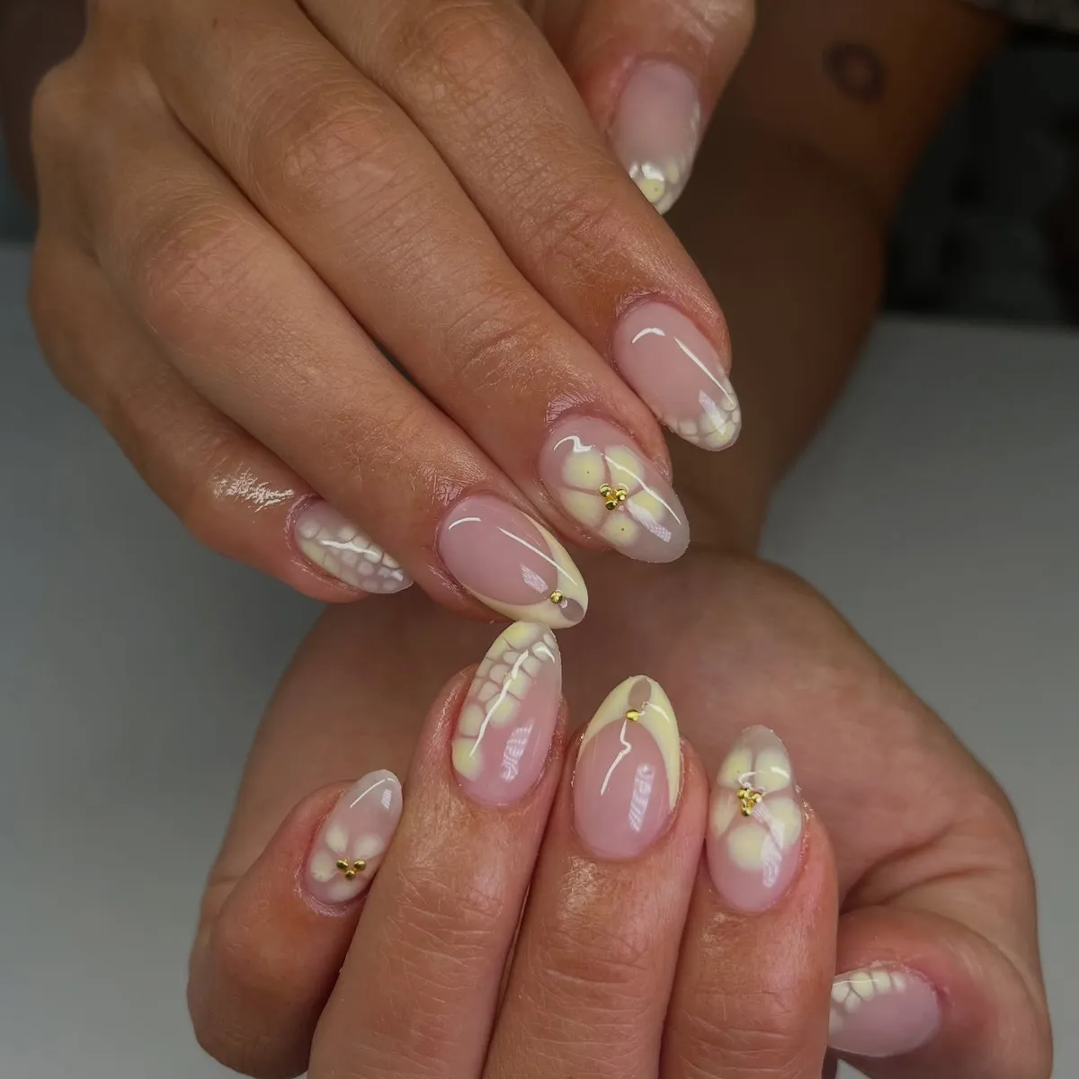Soft yellow French tips with honeycomb and floral accents