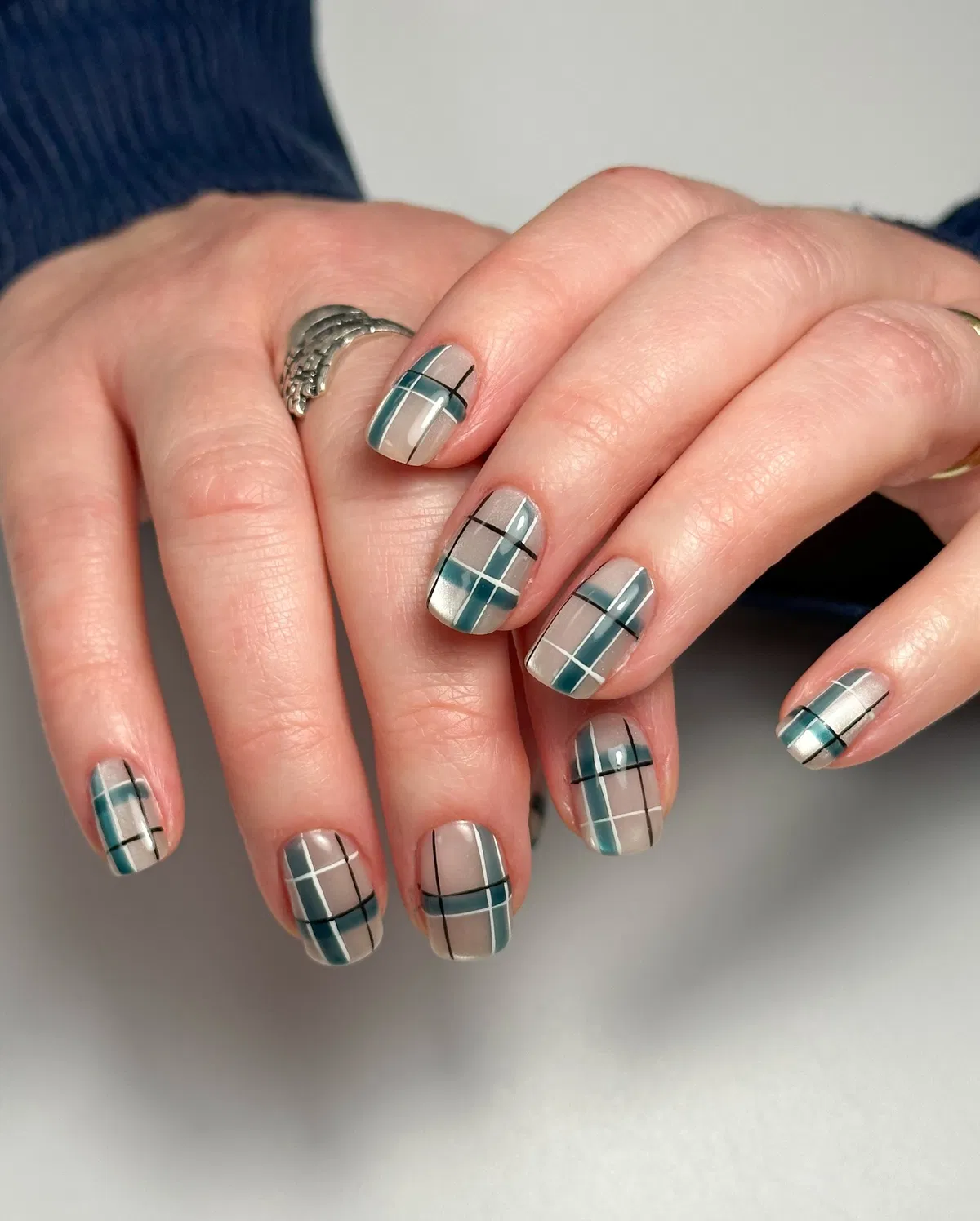 Neutral-and-teal plaid with crisp black and white striping