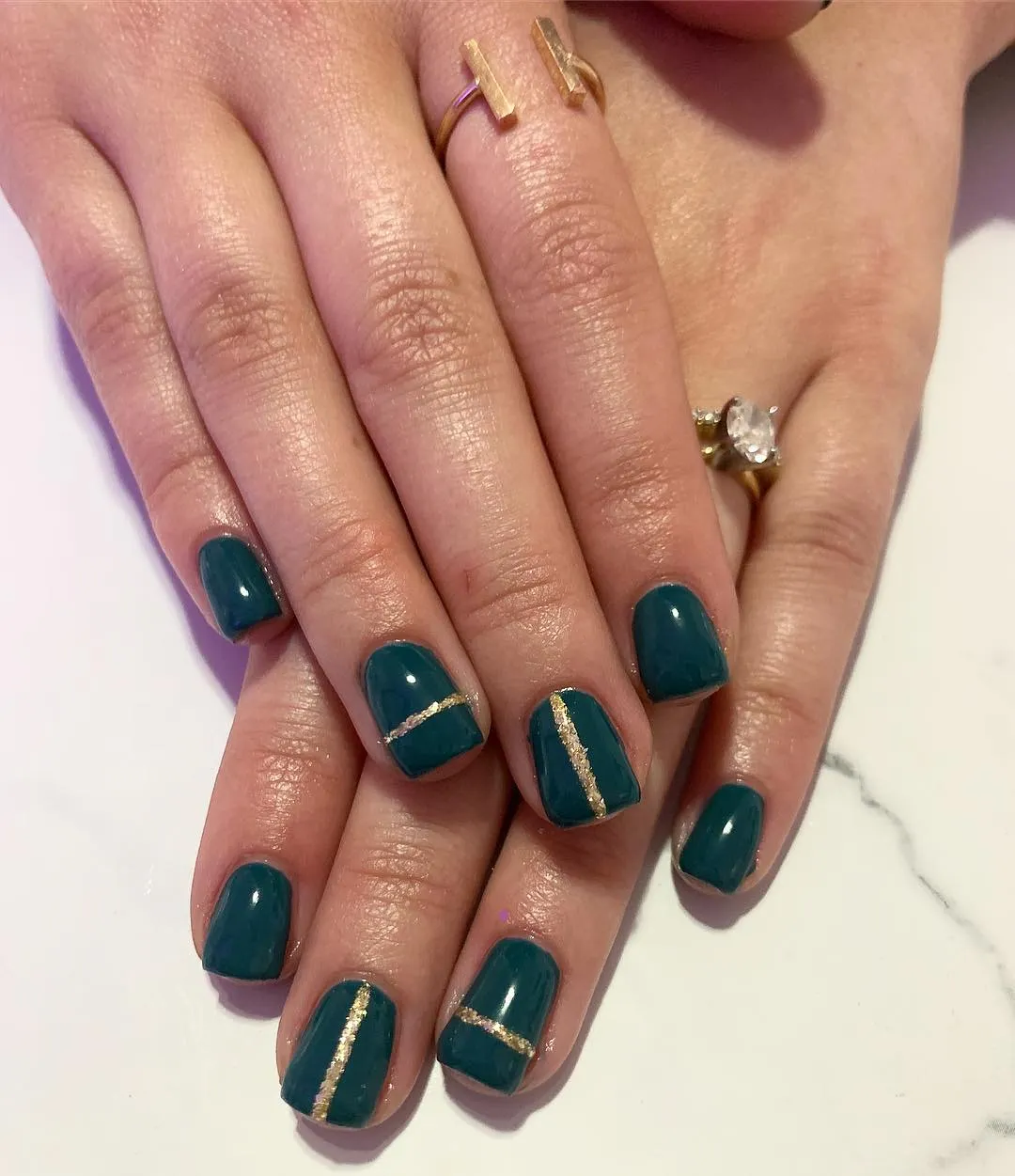 Deep teal gloss with thin gold stripe accents