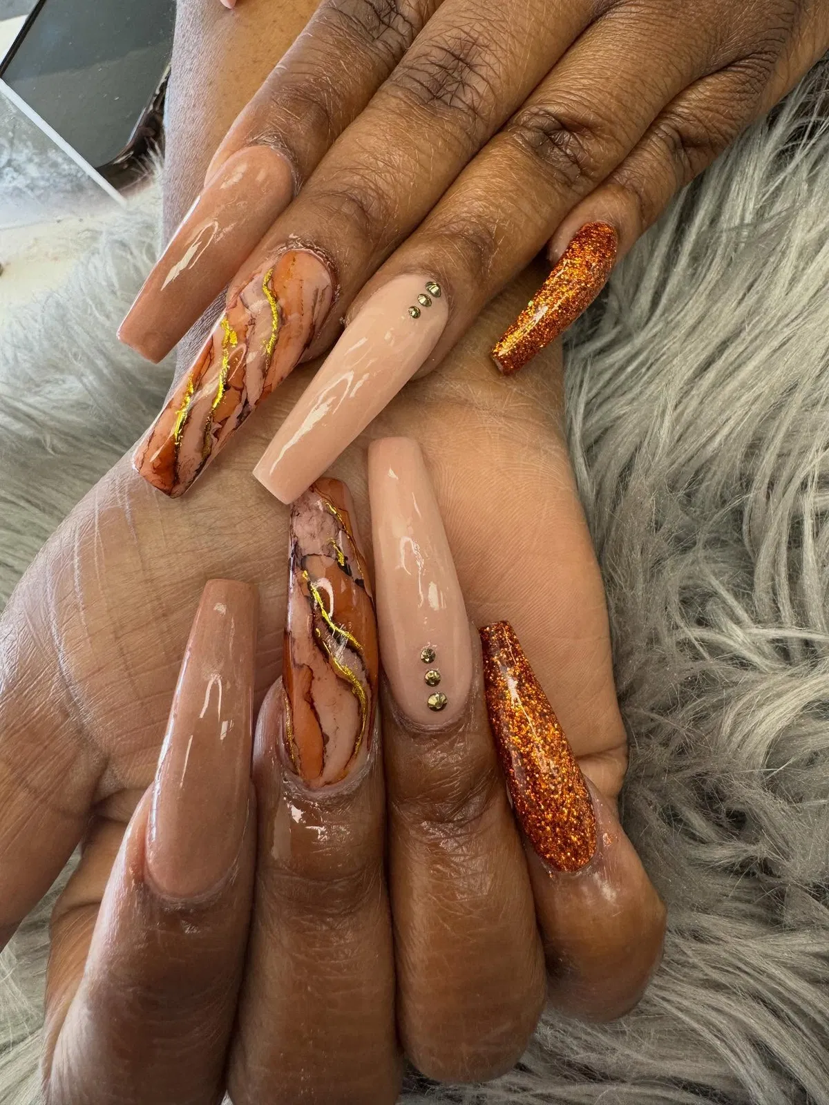 Long nude, orange glitter, and marbled gold-vein accents