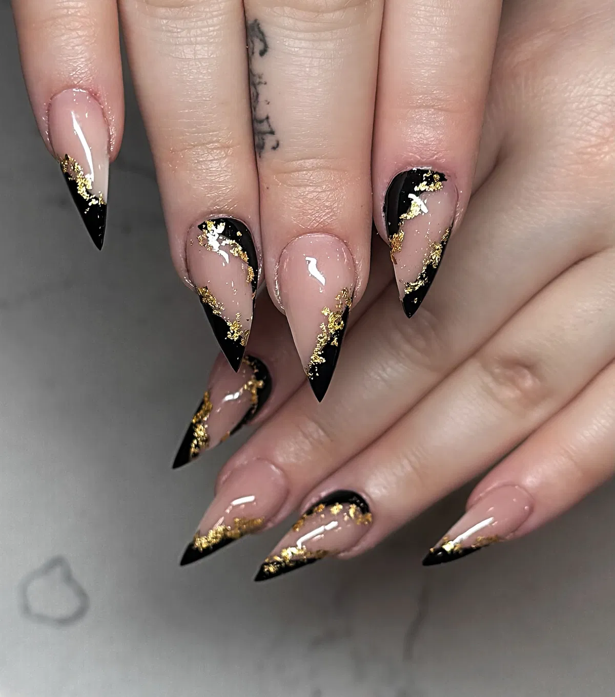 Nude stiletto French with black tips and gold flecks