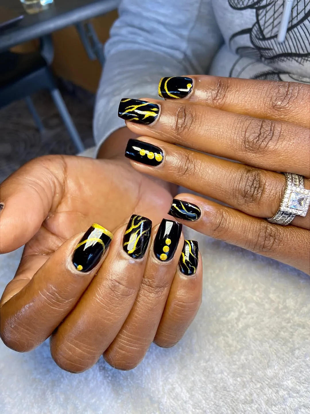 Glossy black with abstract gold lines and dot rows