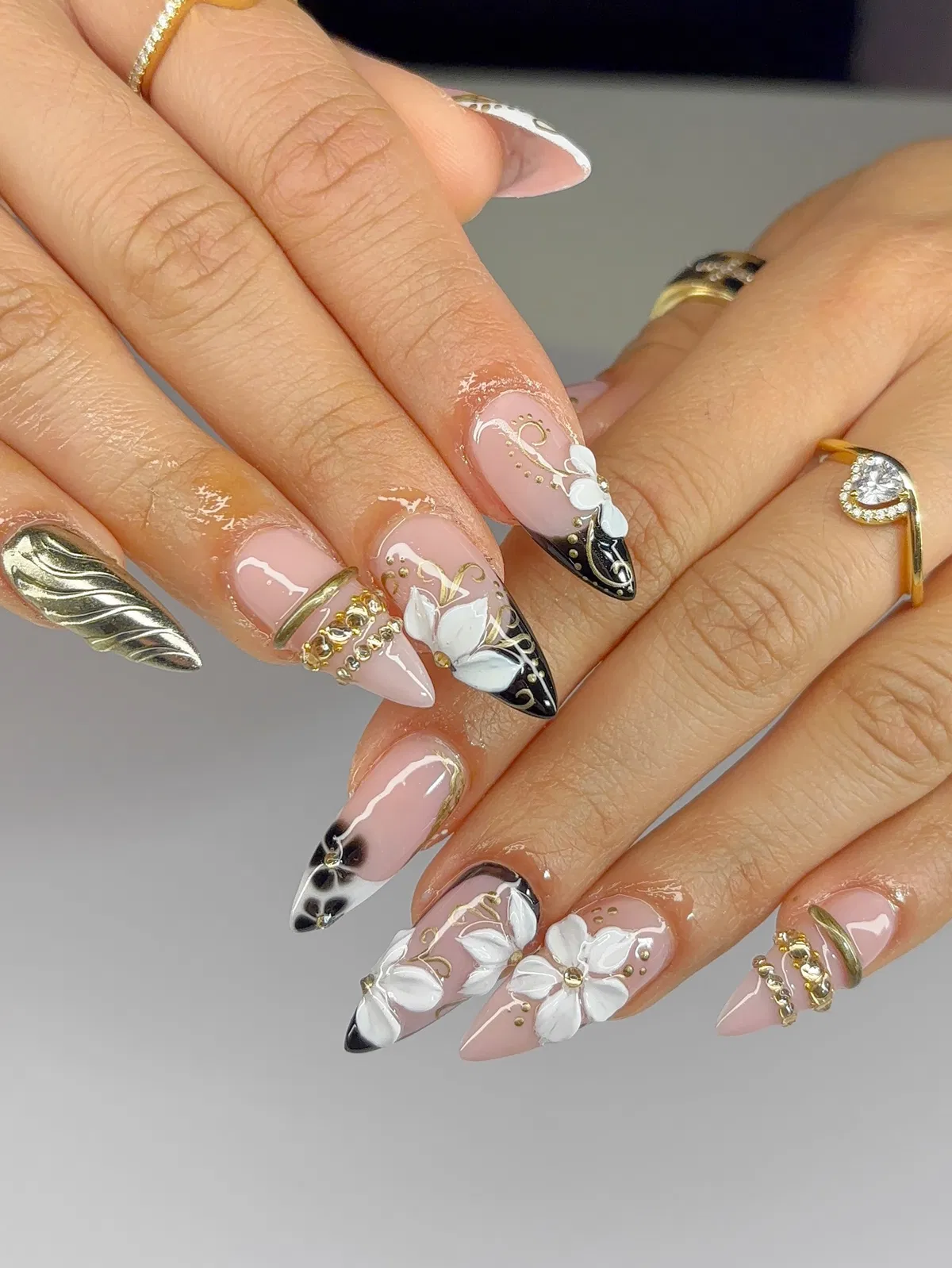 Pink base with black tips, white 3D florals, and gold chain accents