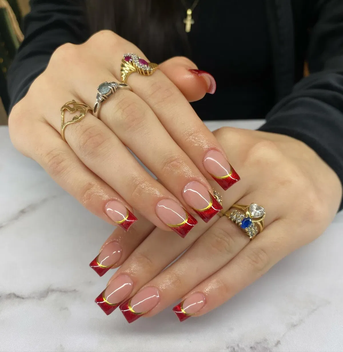 Square nude nails with red French tips and thin gold curves