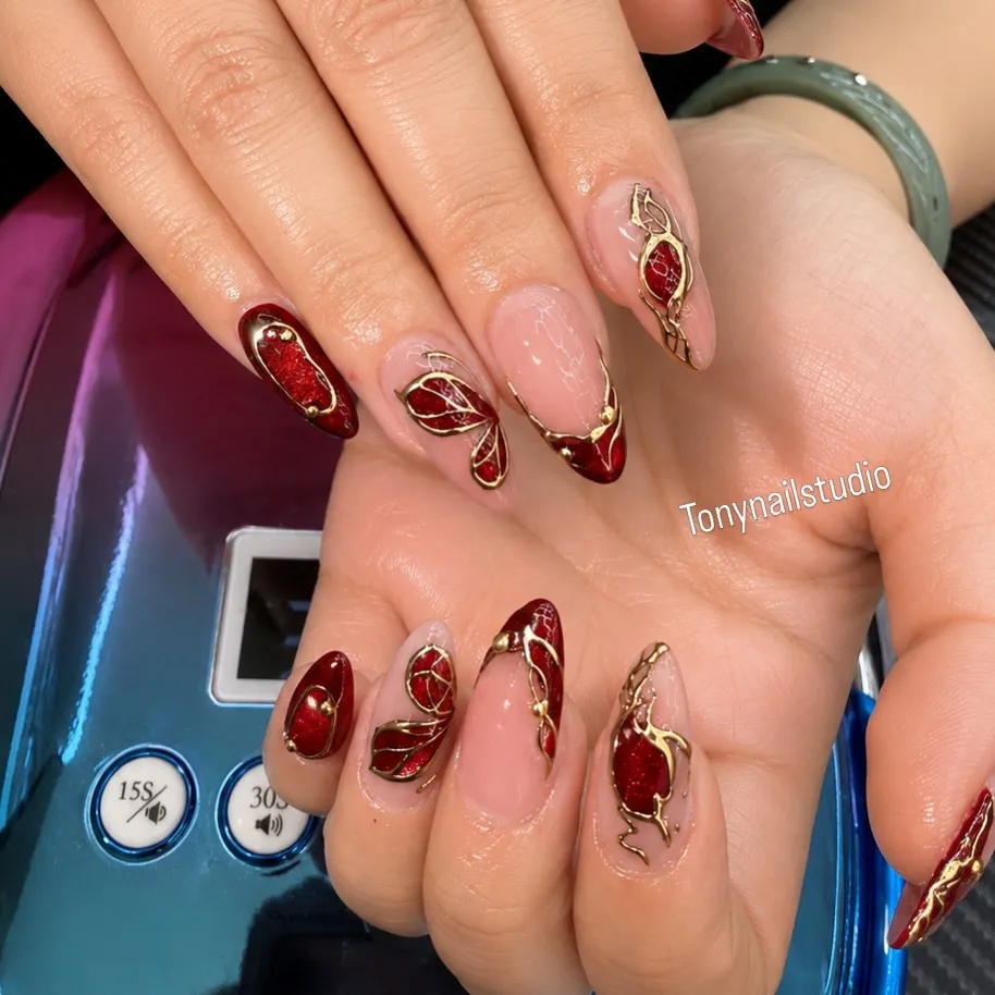 Abstract red glitter and nude nails with gold outlining