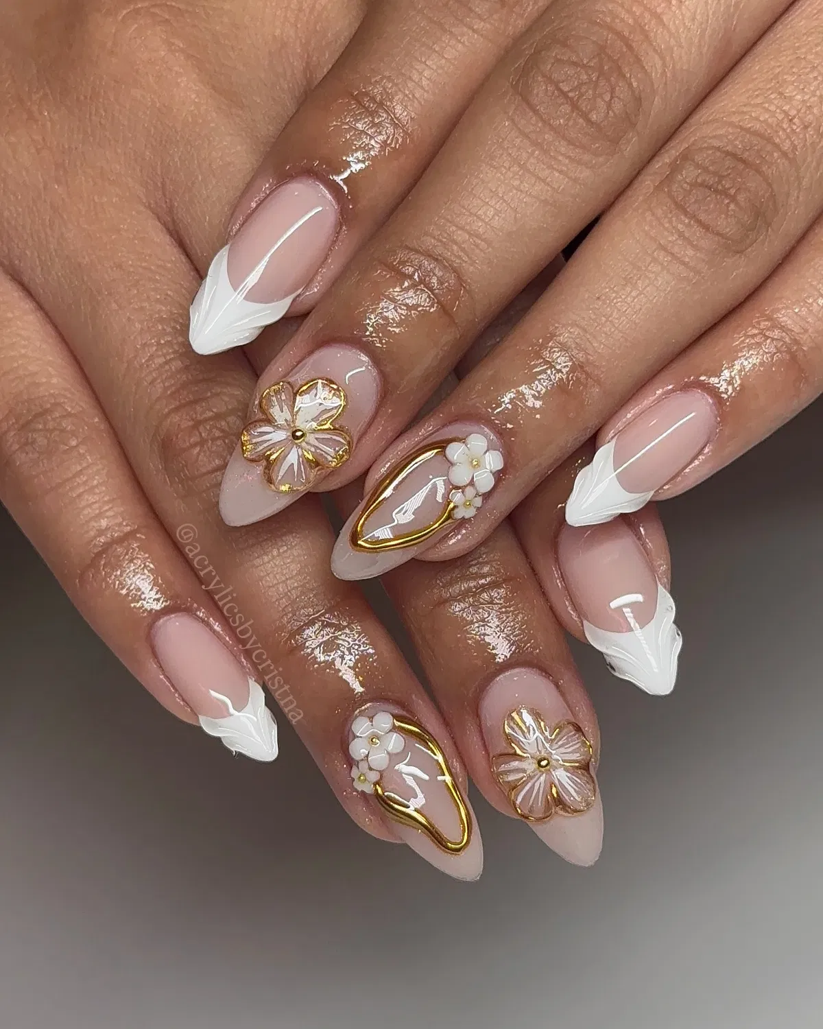Nude almond nails with sculpted white tips and gold-framed accents