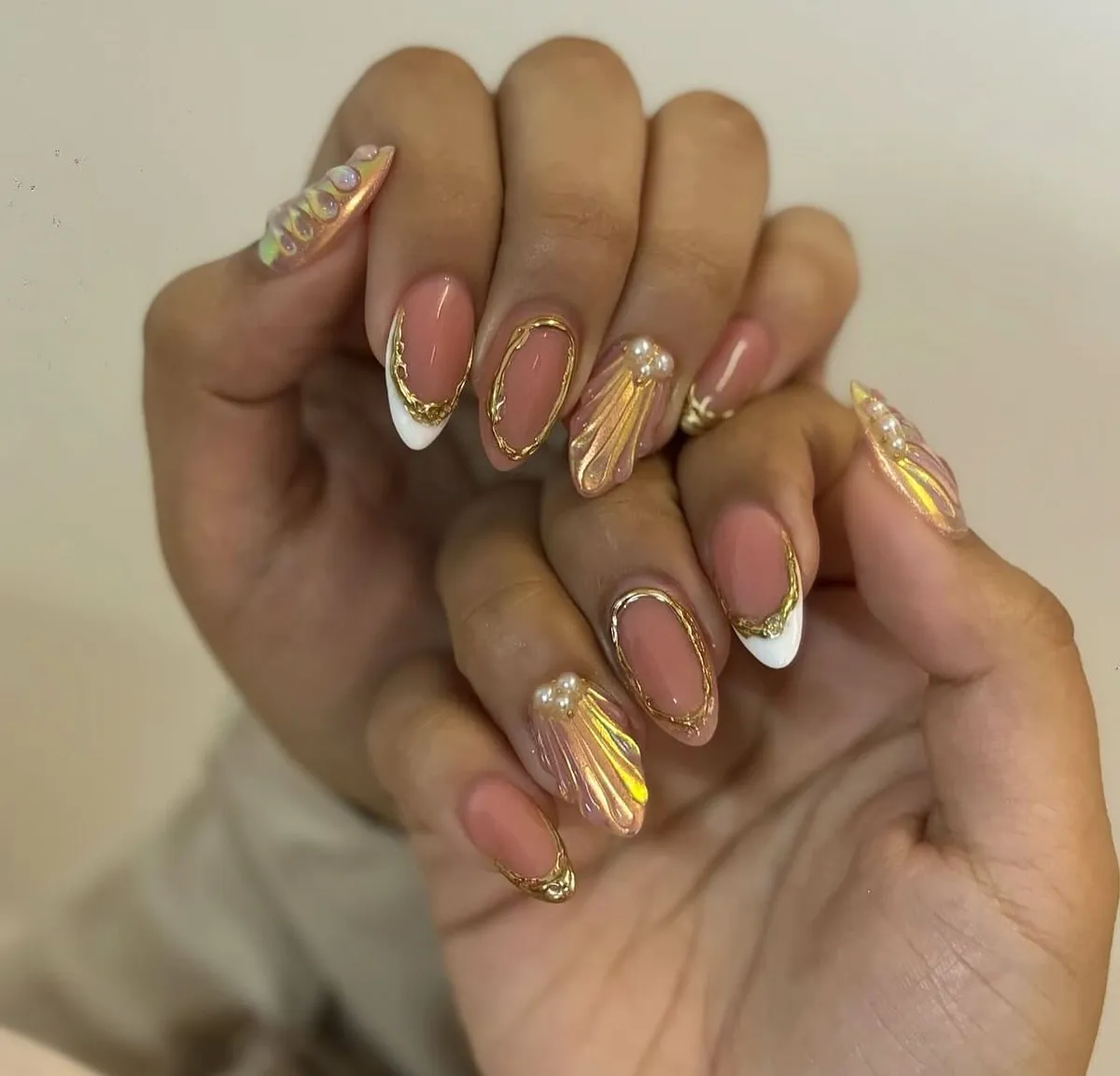 Gold-outlined French tips with shell accent nails
