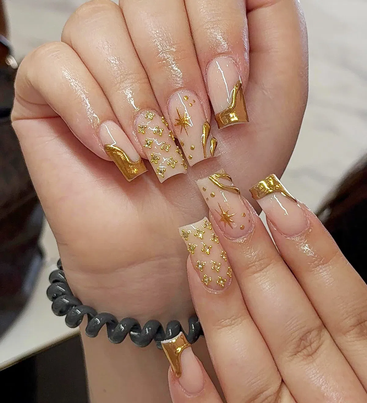 Wavy gold French tips with star accents