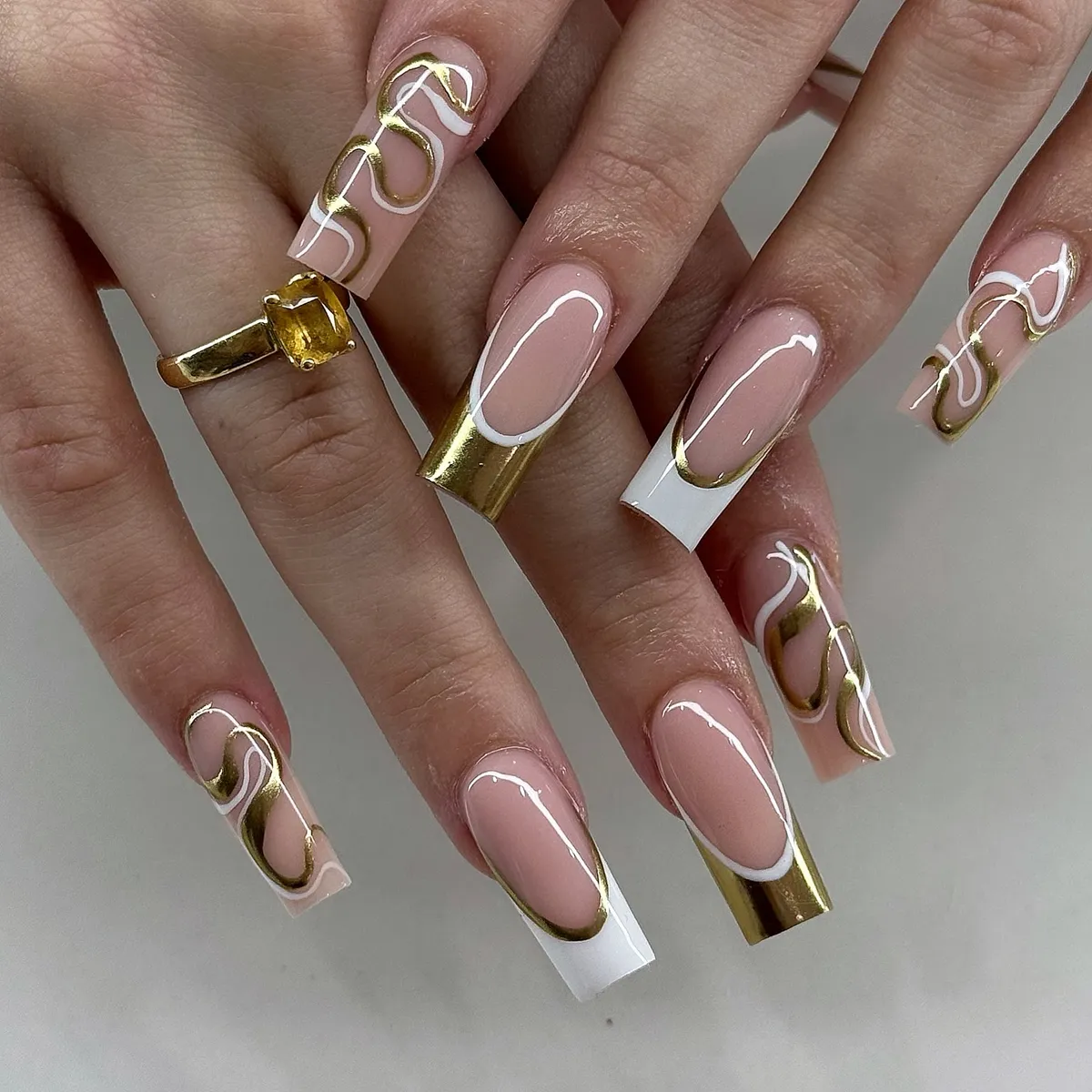Long square French with metallic-gold tips and wavy lines
