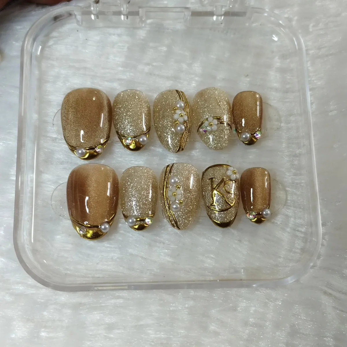 Gold glitter set with pearls, flowers, and a “K” accent