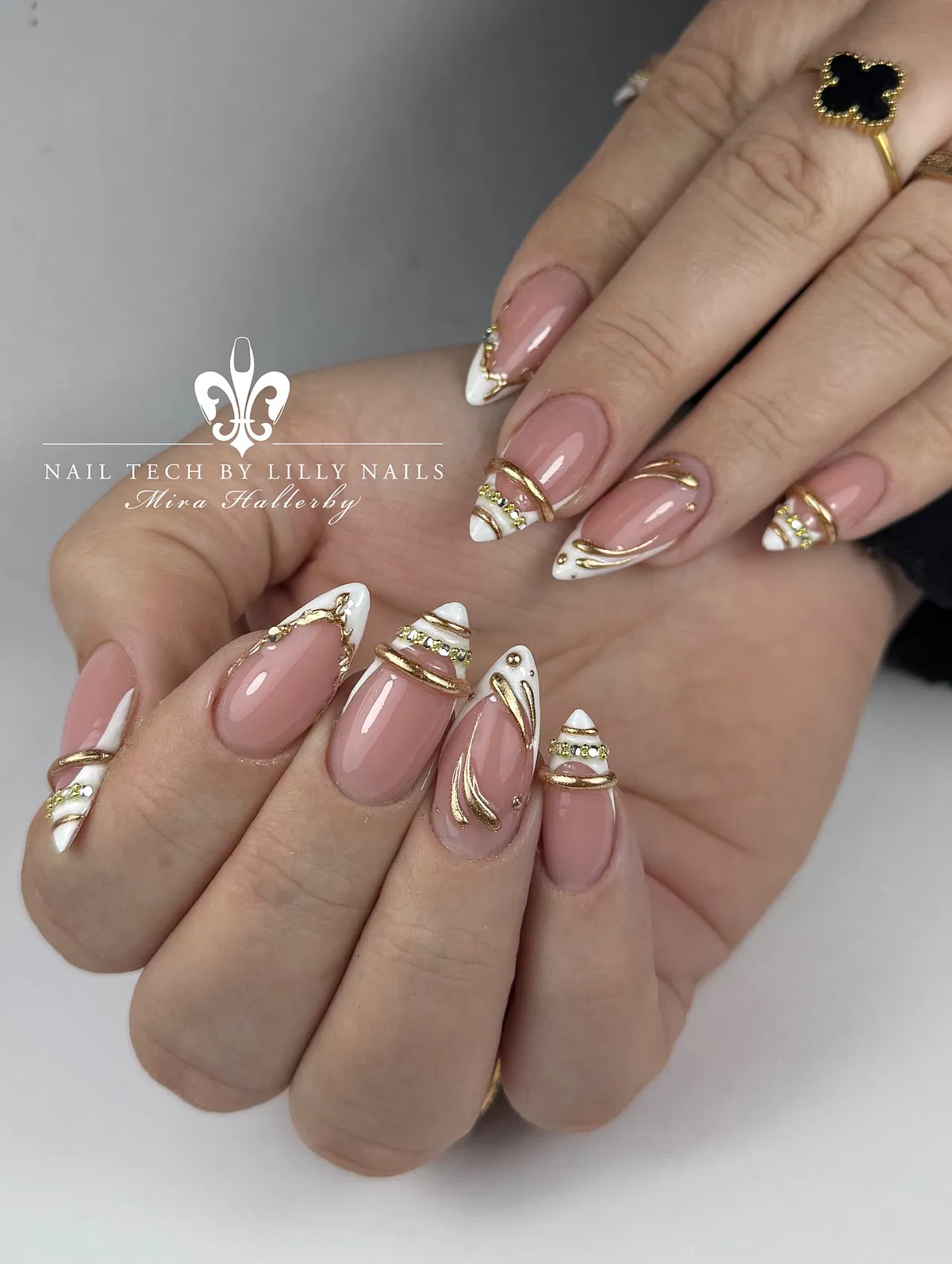 Pink-nude almond nails with gold striping and white tips