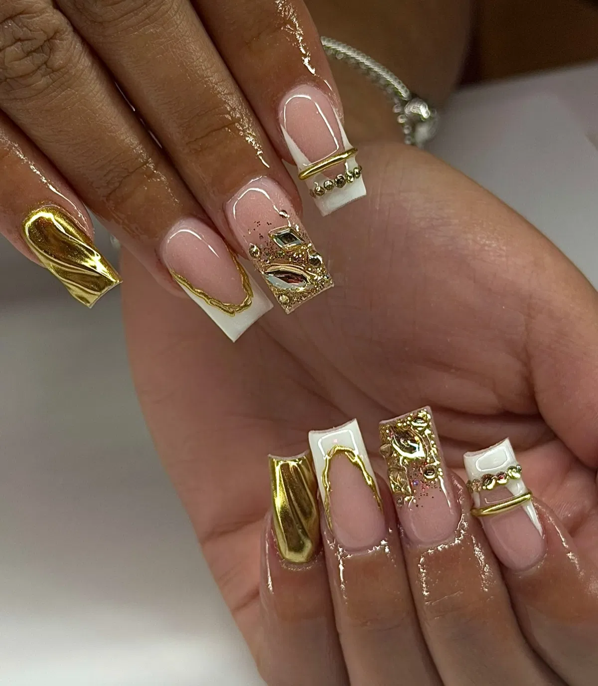 White French tips with metallic gold and gem accents