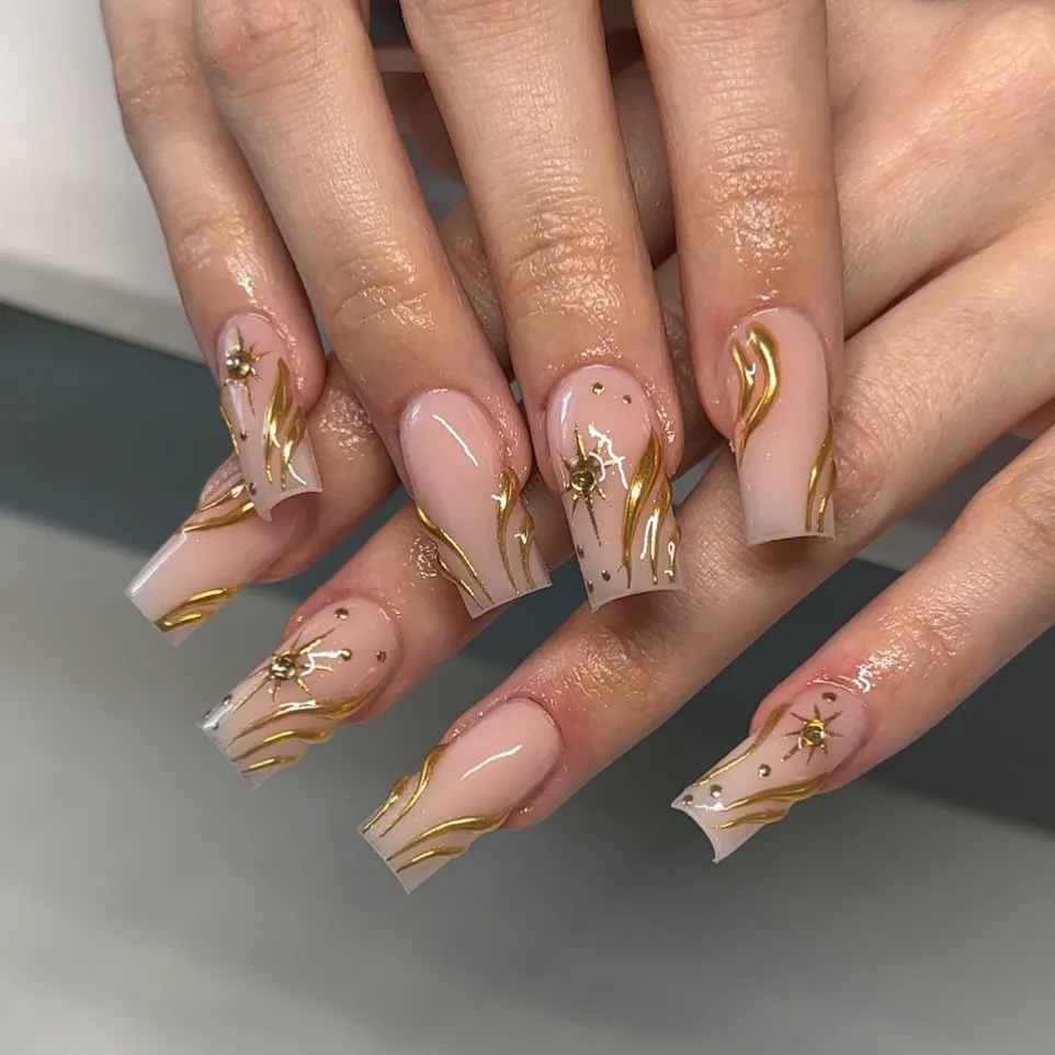 Gold wavy line art with starburst accents on nude base