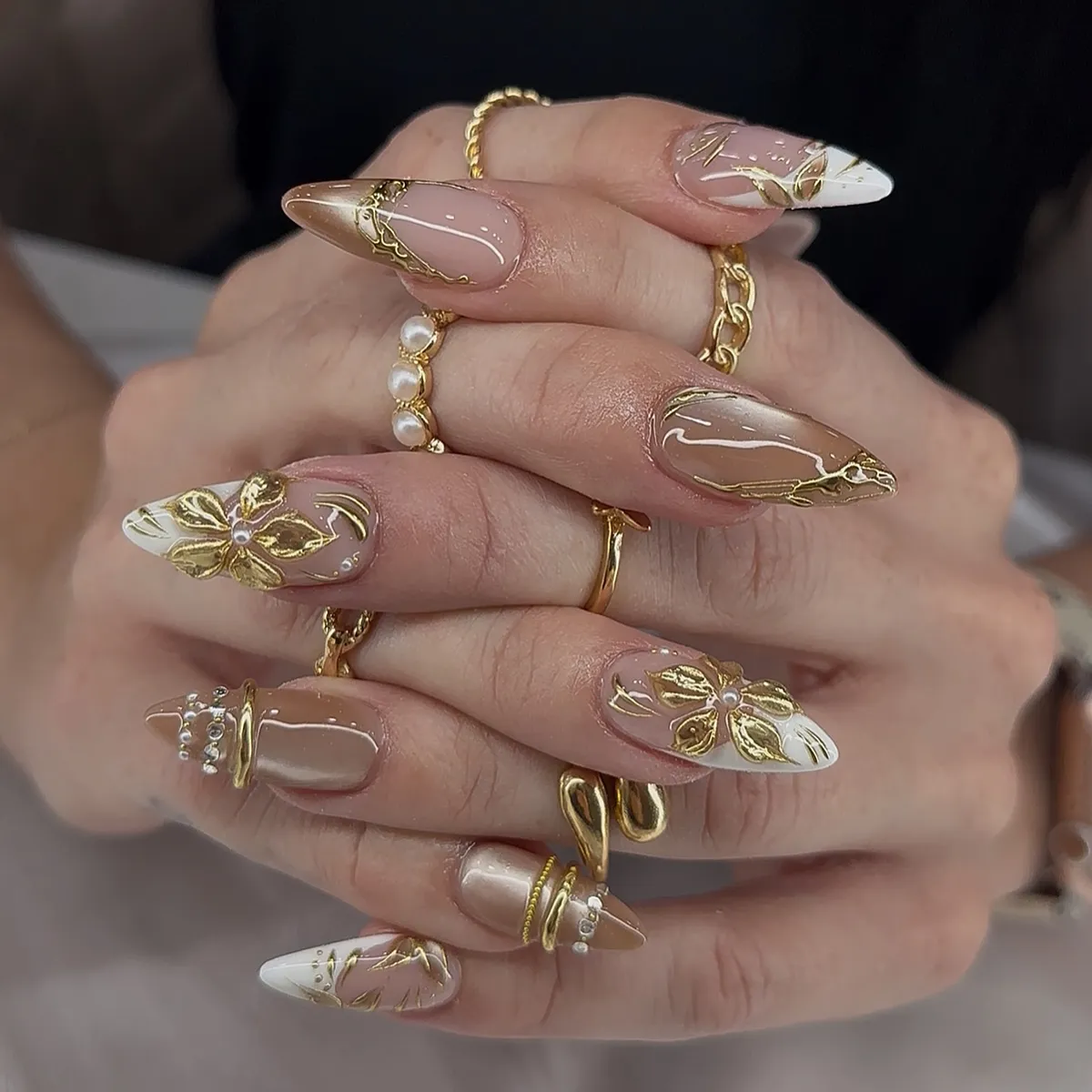 Gold floral overlays on nude and white-tipped nails