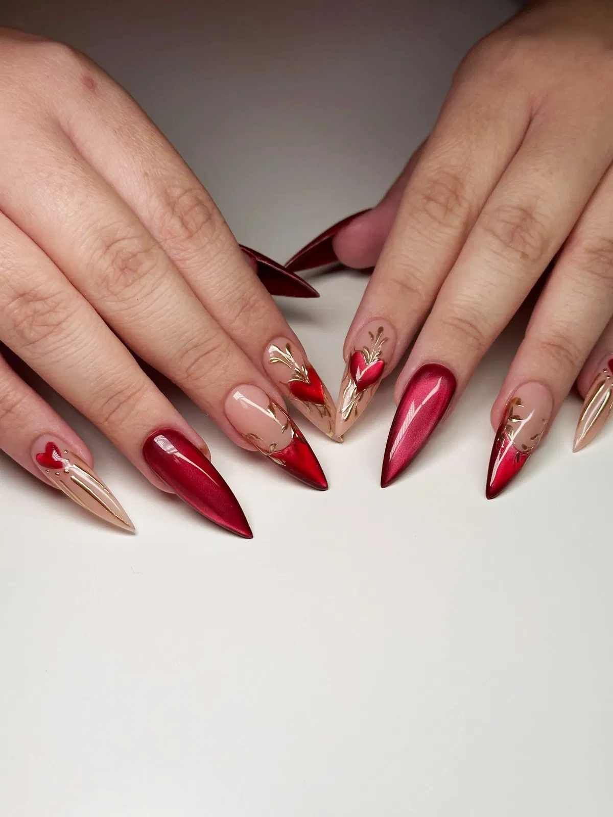Deep red stilettos with gold linework and heart accents