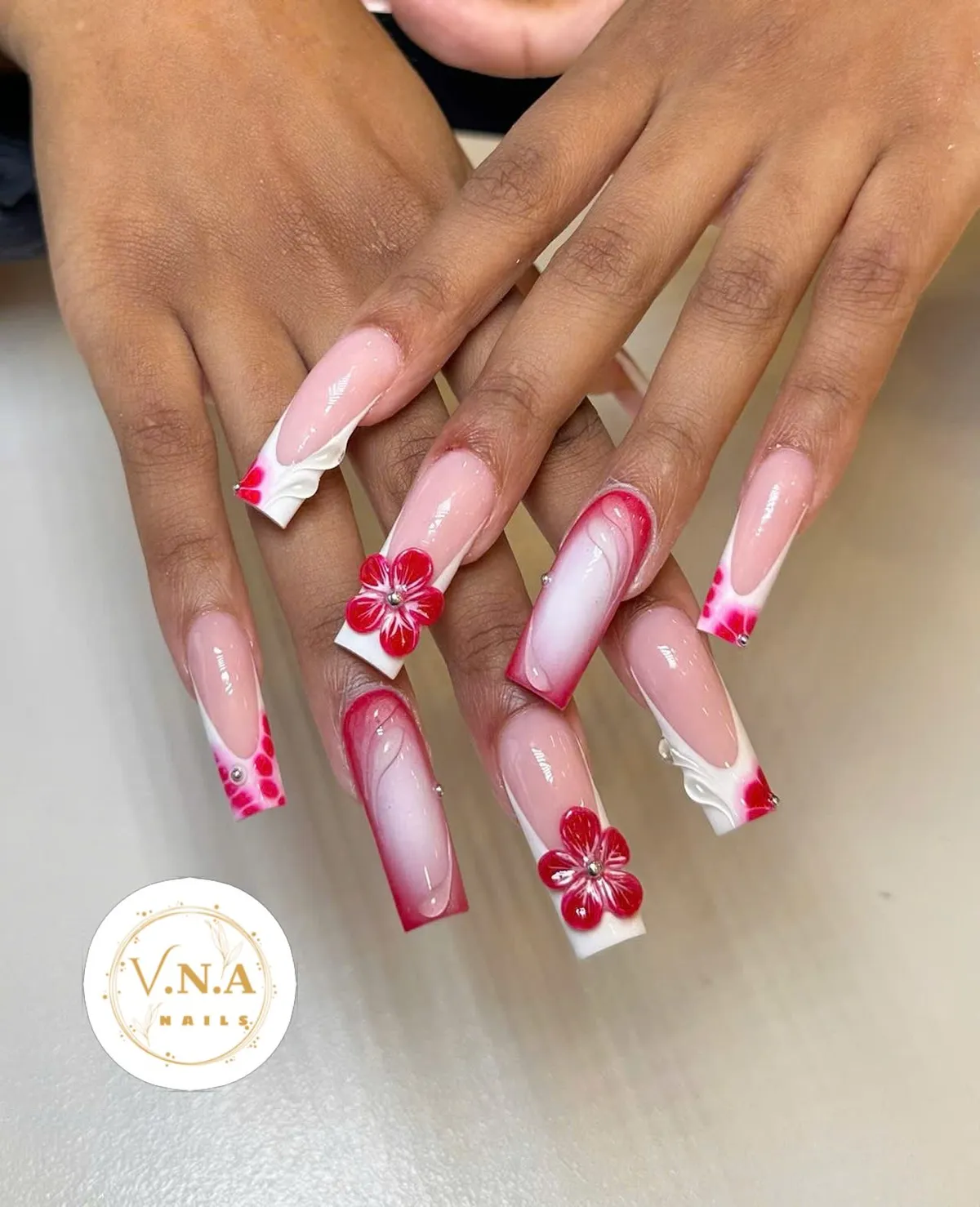 Nude-and-white long nails with red gradients and 3D red flowers
