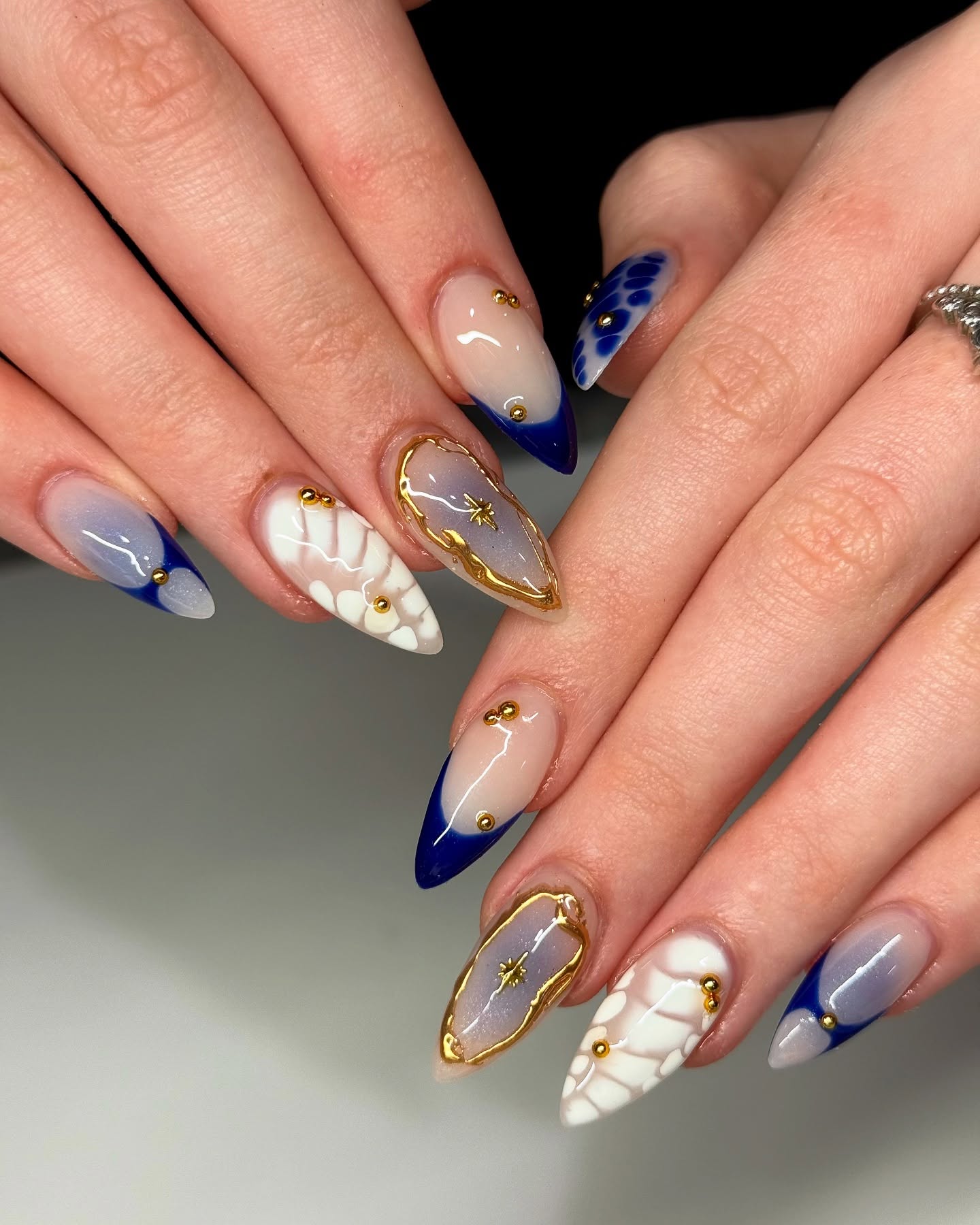 Blue French tips with gold studs and gray/white accents